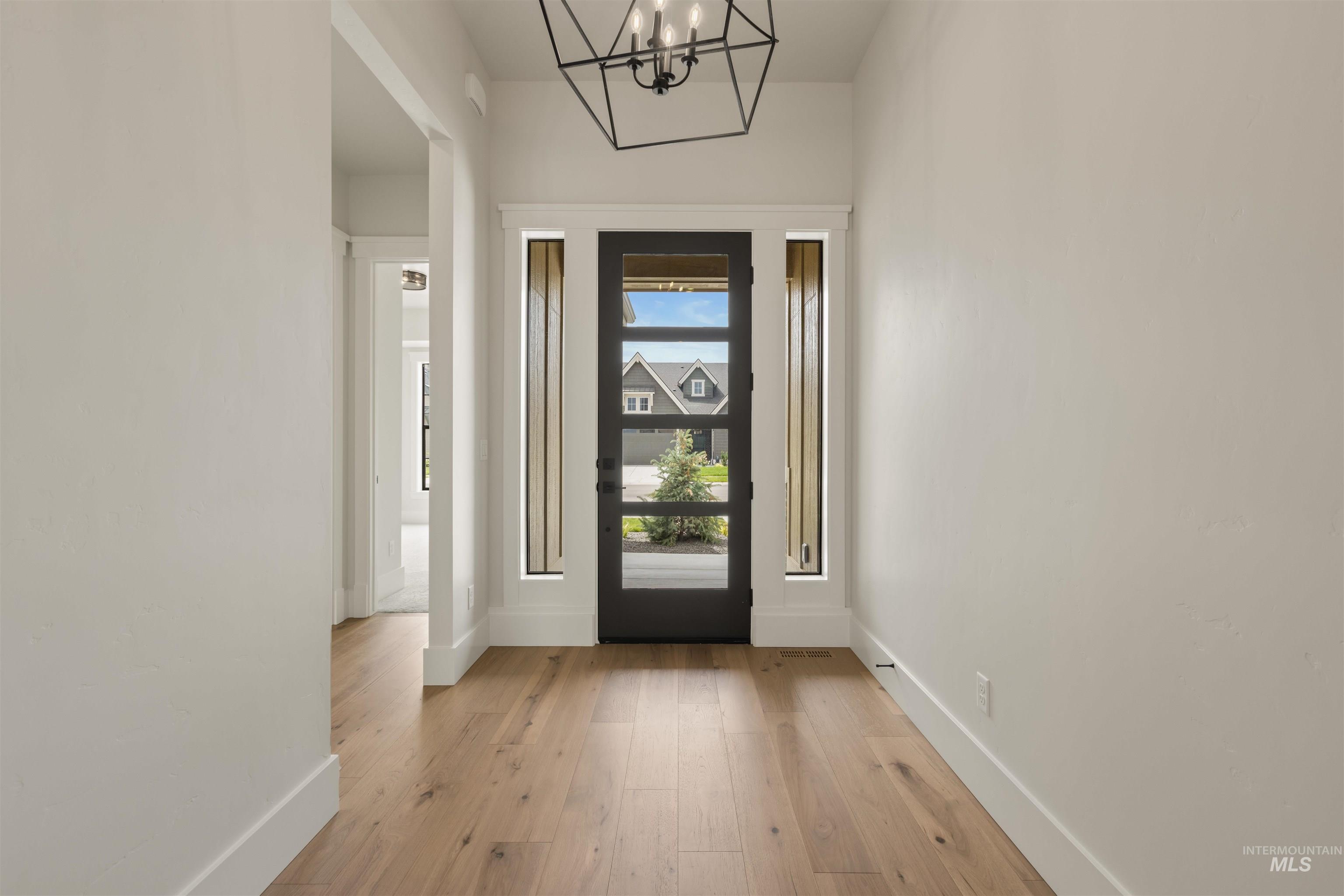 Entryway featuring light wood-type flooring and a chandelier