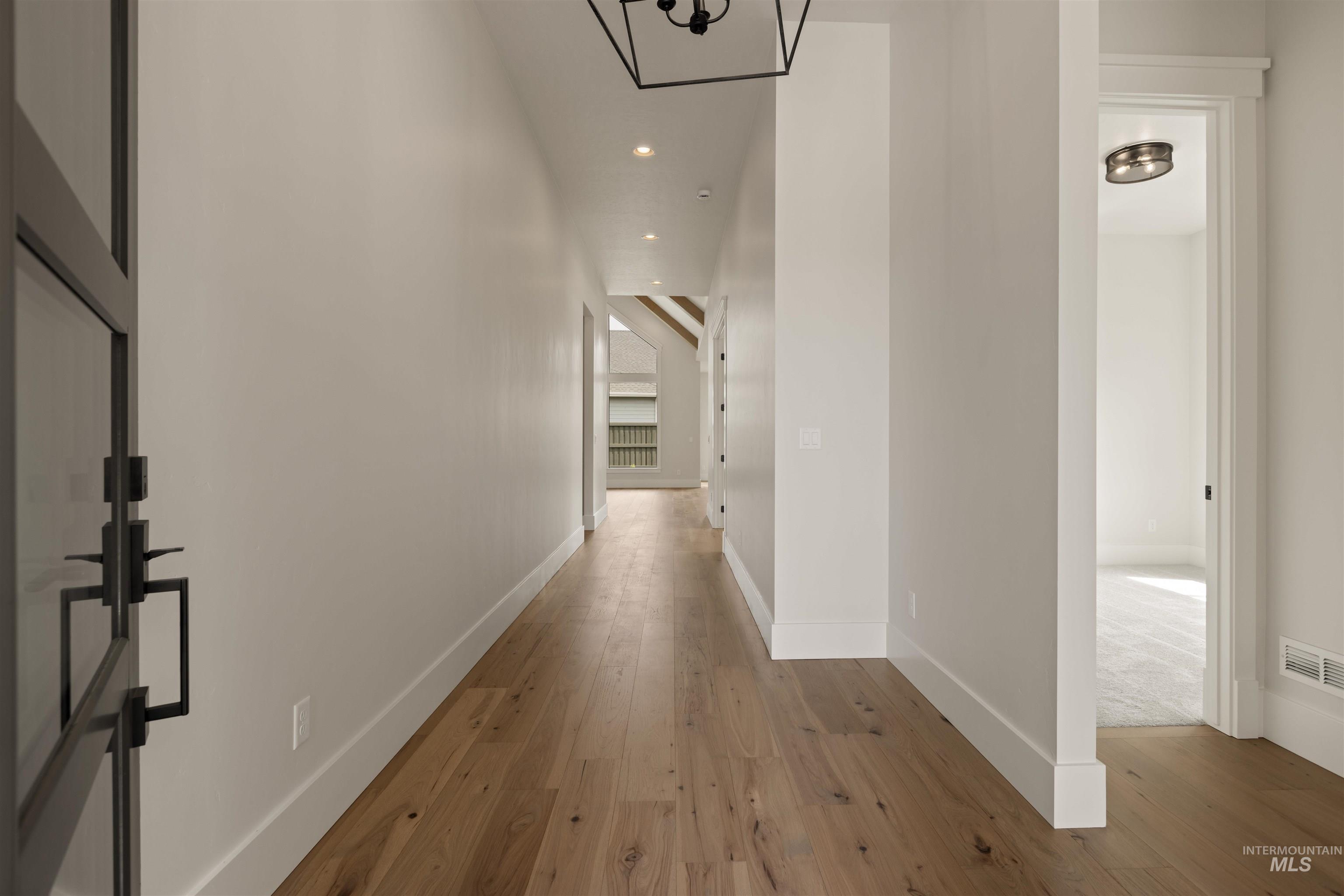 Hall with recessed lighting, hardwood / wood-style flooring, and a chandelier