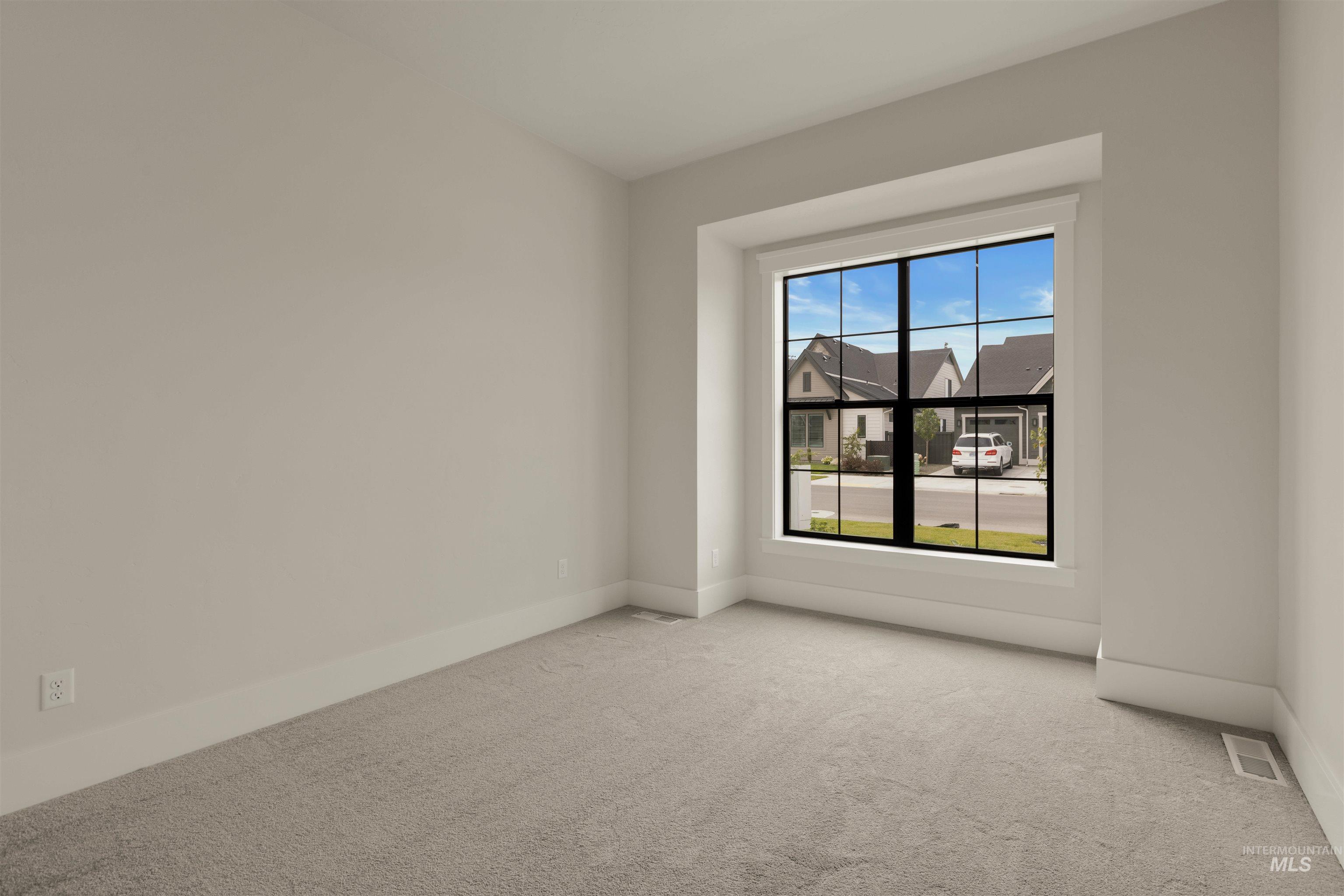 Carpeted spare room with baseboards