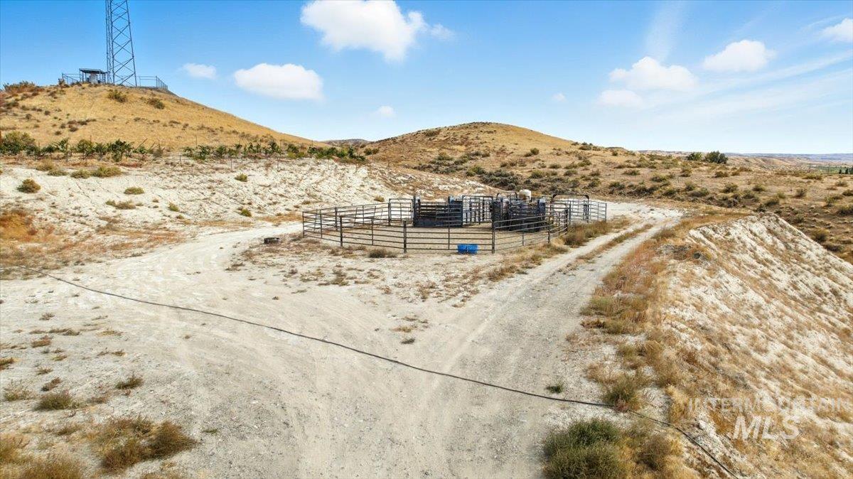 View of road with a mountain view, a rural view, and a gated entry