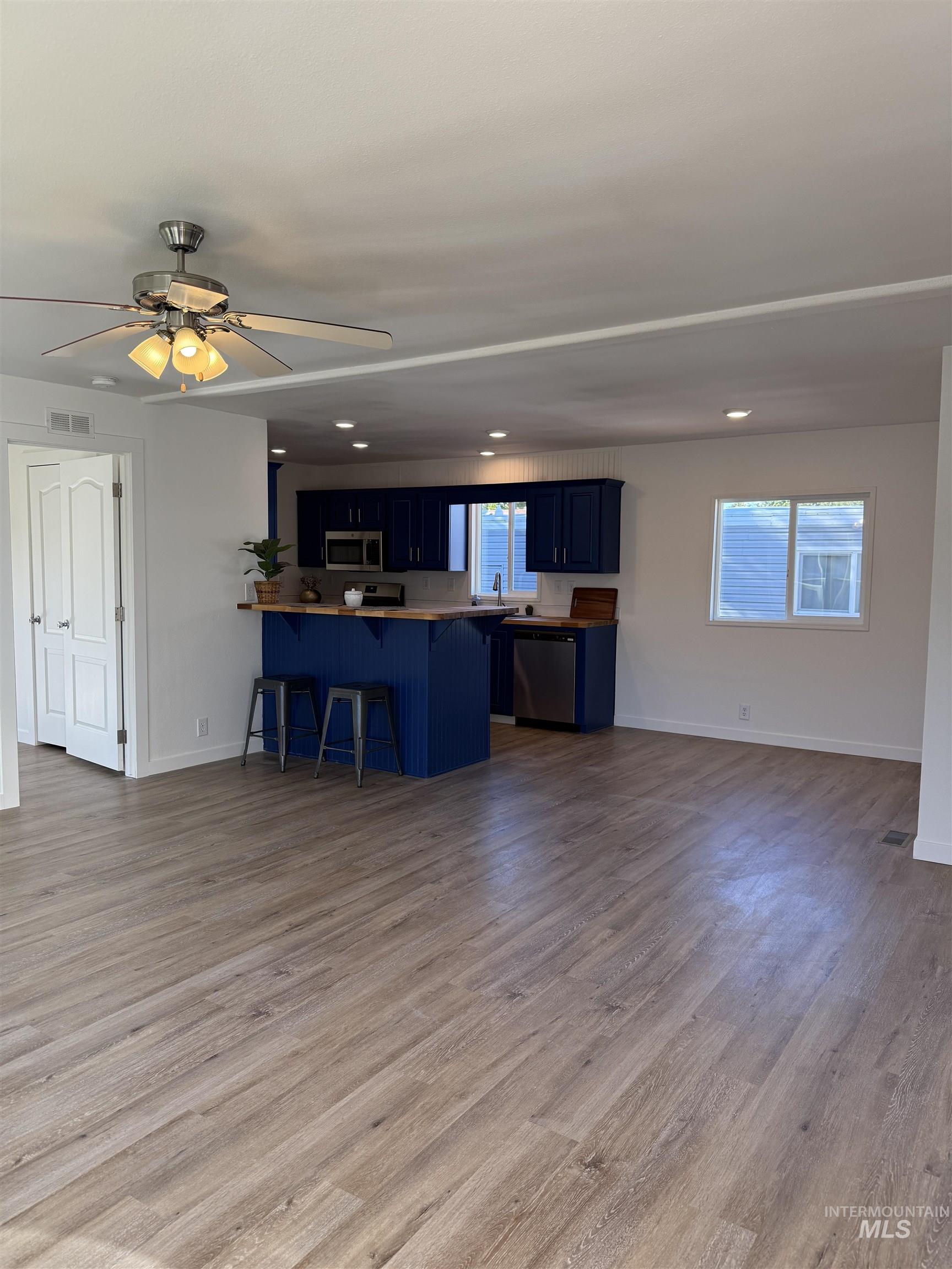Kitchen with blue cabinets, a peninsula, a breakfast bar area, healthy amount of natural light, and recessed lighting