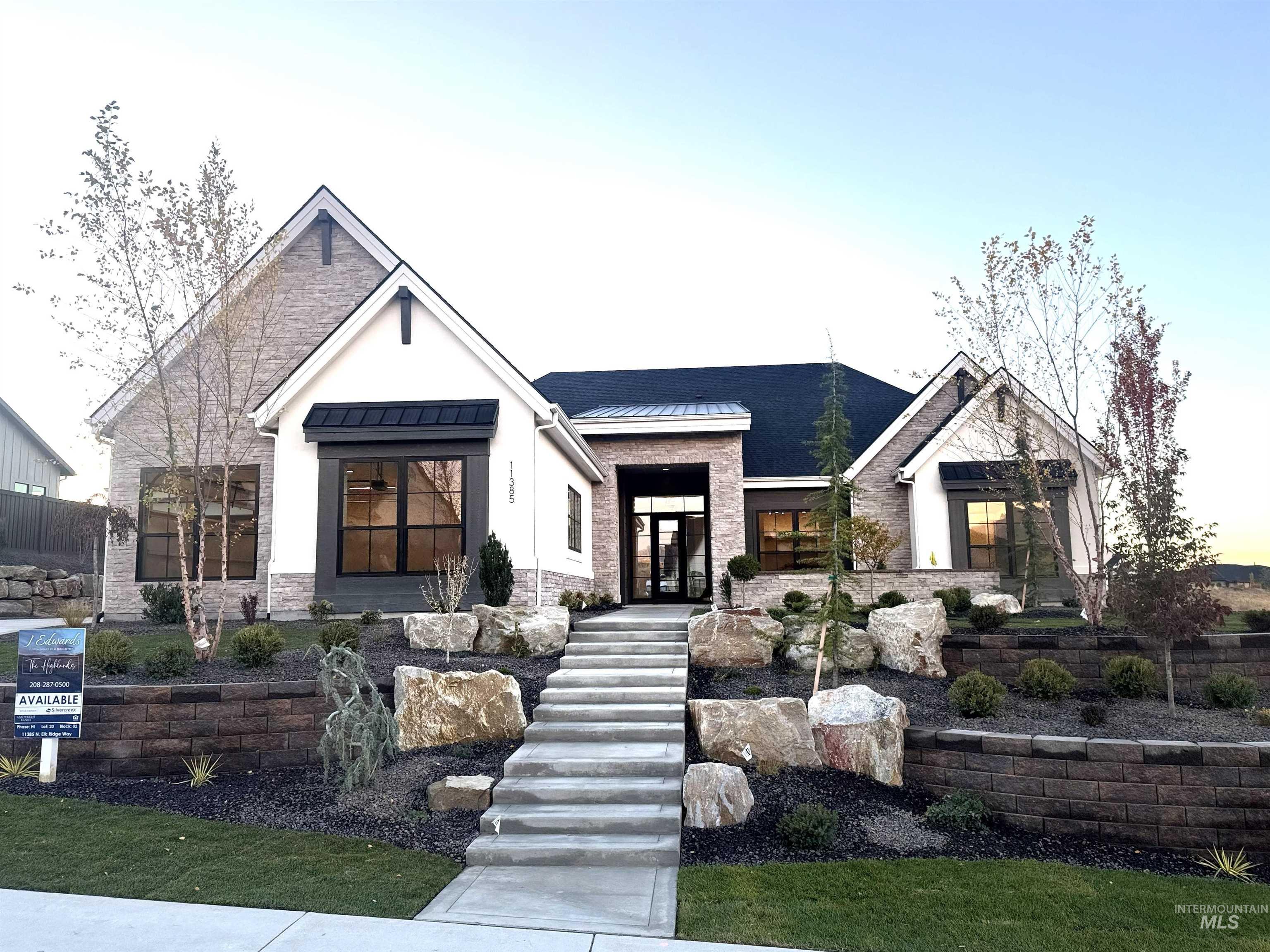 Modern inspired farmhouse featuring a standing seam roof, a metal roof, stone siding, and stairway