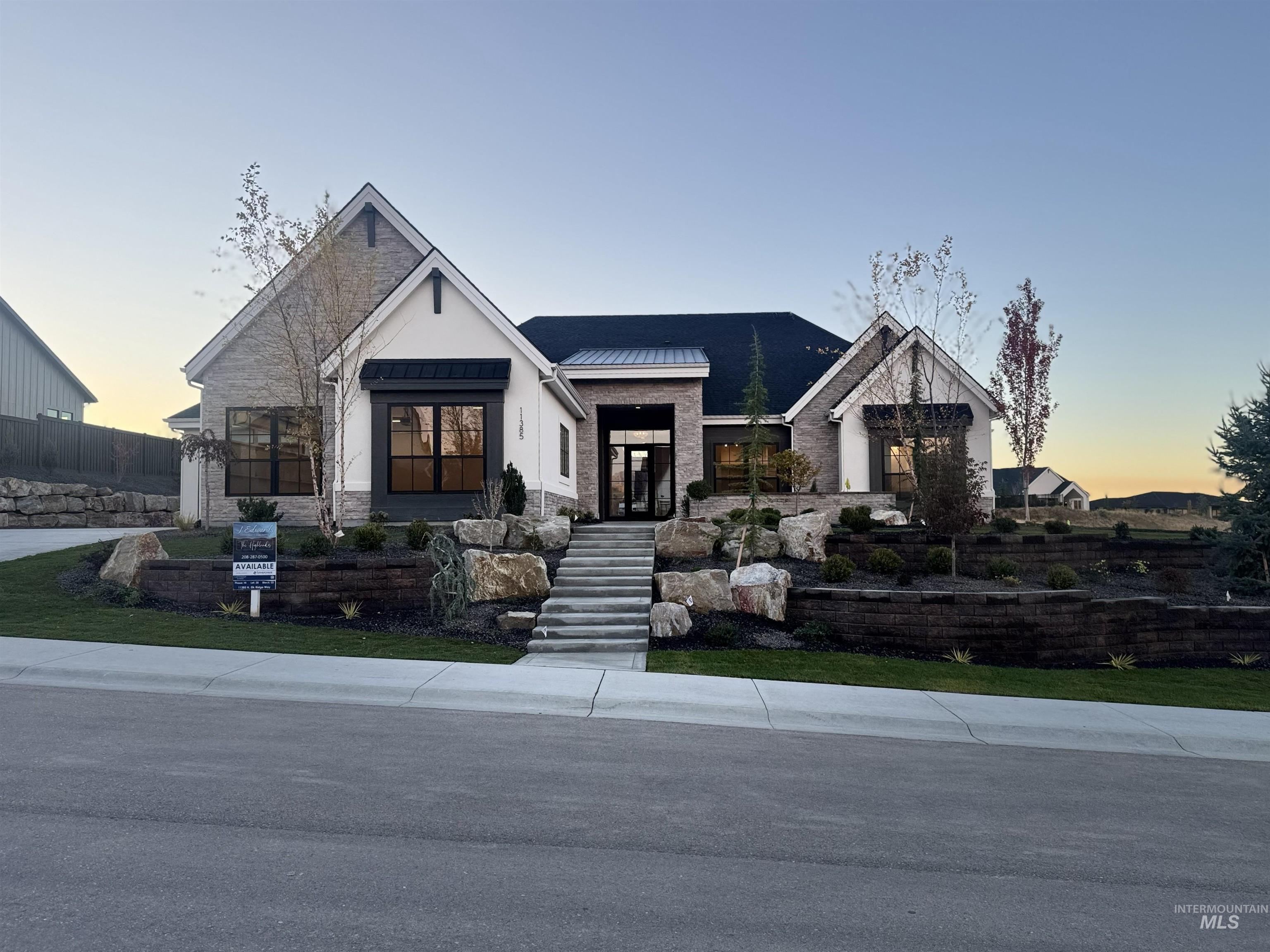 Modern farmhouse with stone siding, a standing seam roof, and a metal roof