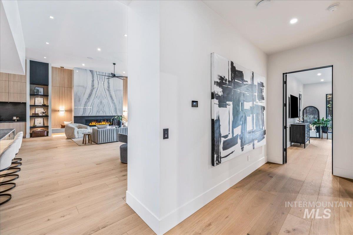 Hall with light wood-type flooring and recessed lighting