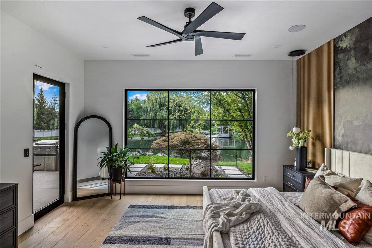 Bedroom with hardwood / wood-style flooring, access to exterior, and ceiling fan