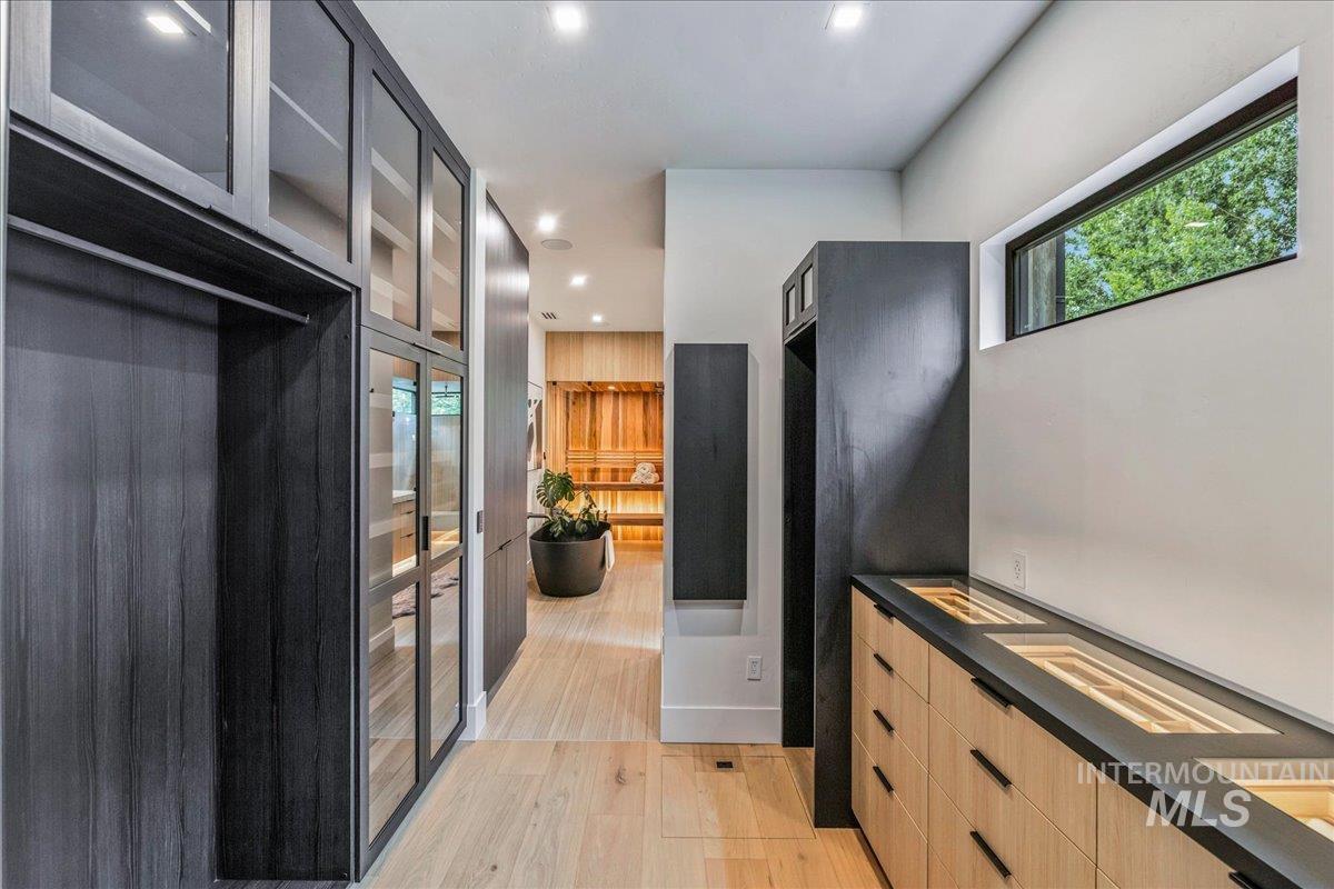 Kitchen featuring glass insert cabinets, recessed lighting, light wood-style floors, modern cabinets, and light brown cabinetry
