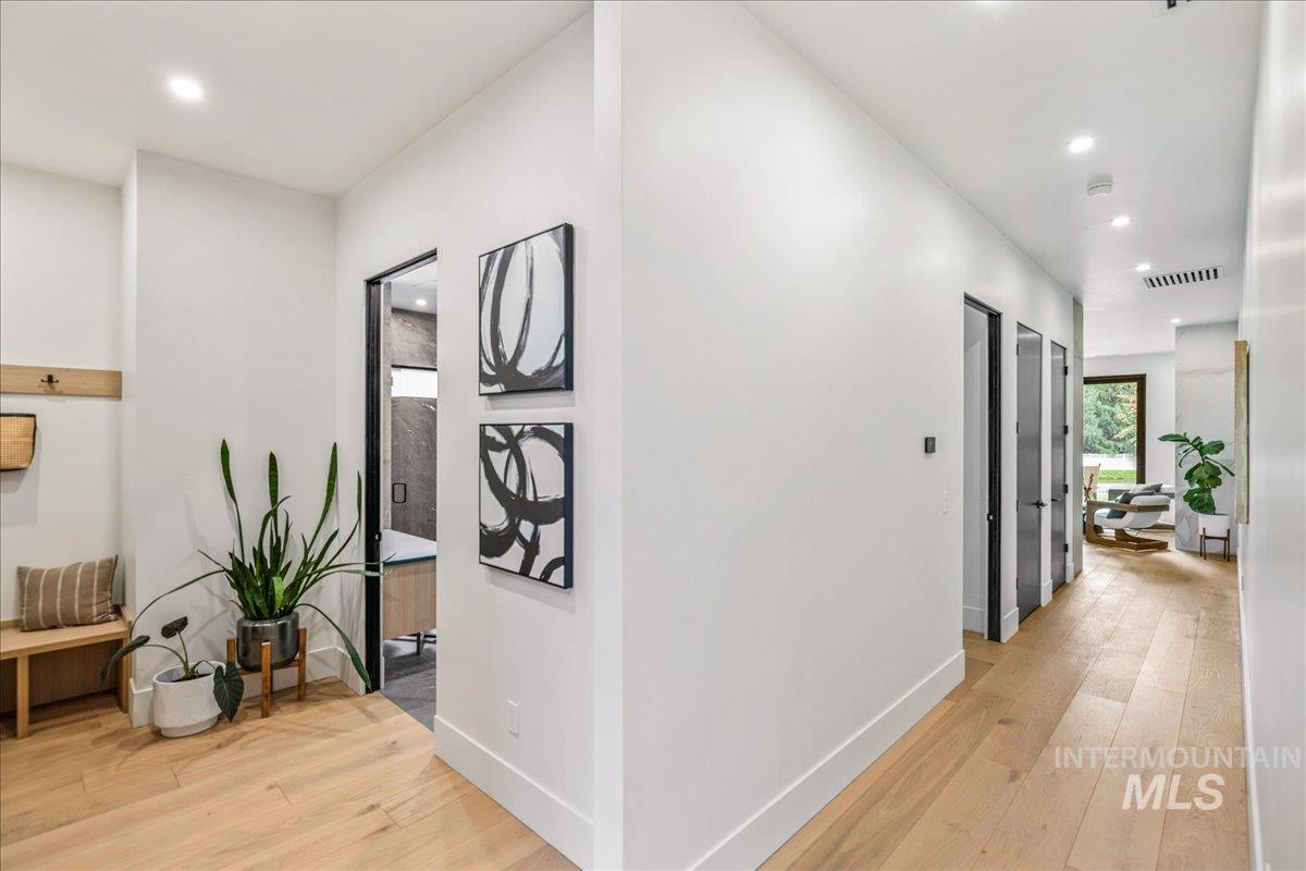 Hall featuring light wood finished floors and recessed lighting