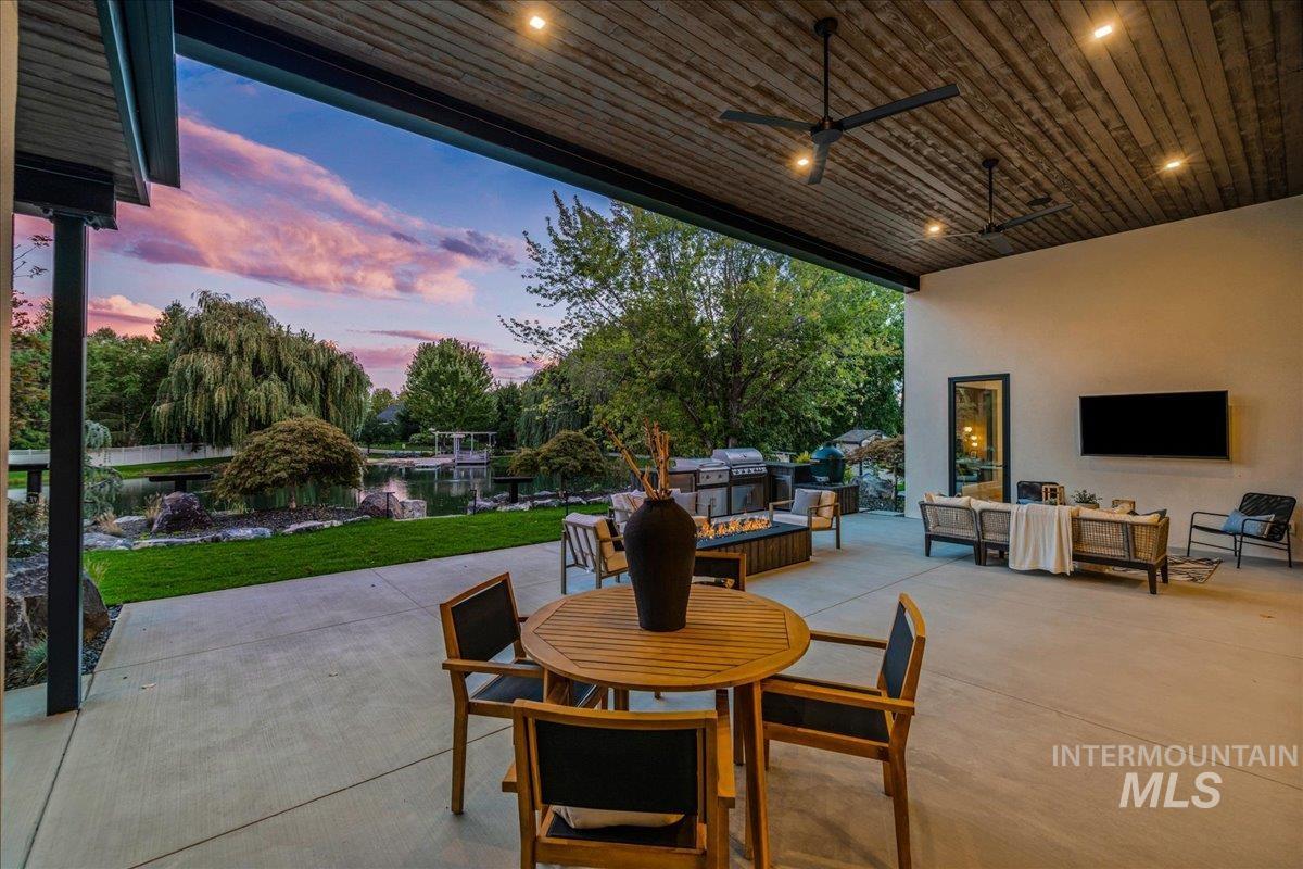 View of patio with an outdoor hangout area, outdoor dining area, a ceiling fan, and grilling area