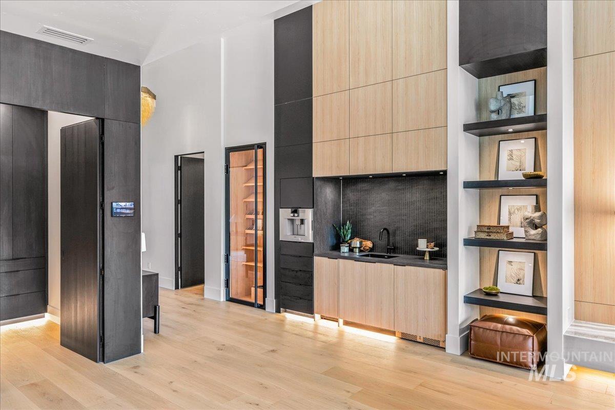 Kitchen featuring light brown cabinetry, modern cabinets, open shelves, and a high ceiling