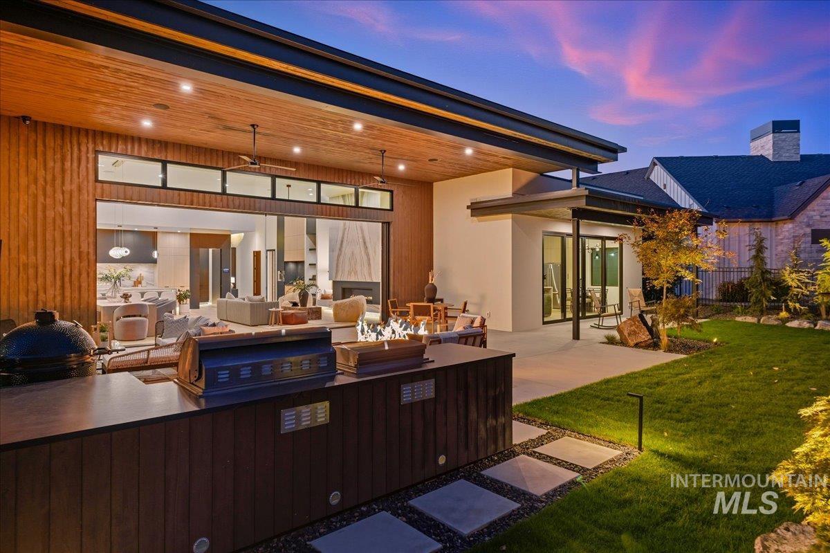 Back of house at dusk with a patio and stucco siding