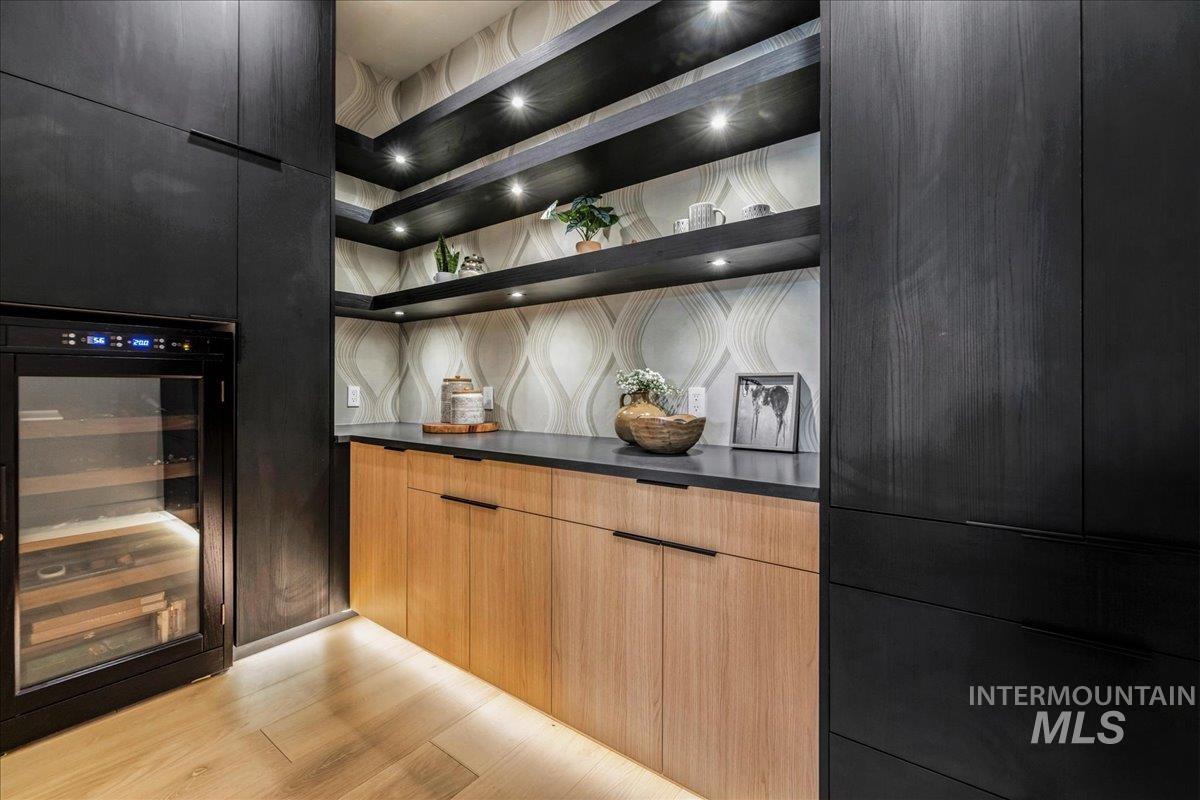 Kitchen featuring wine cooler, modern cabinets, open shelves, light wood finished floors, and decorative backsplash