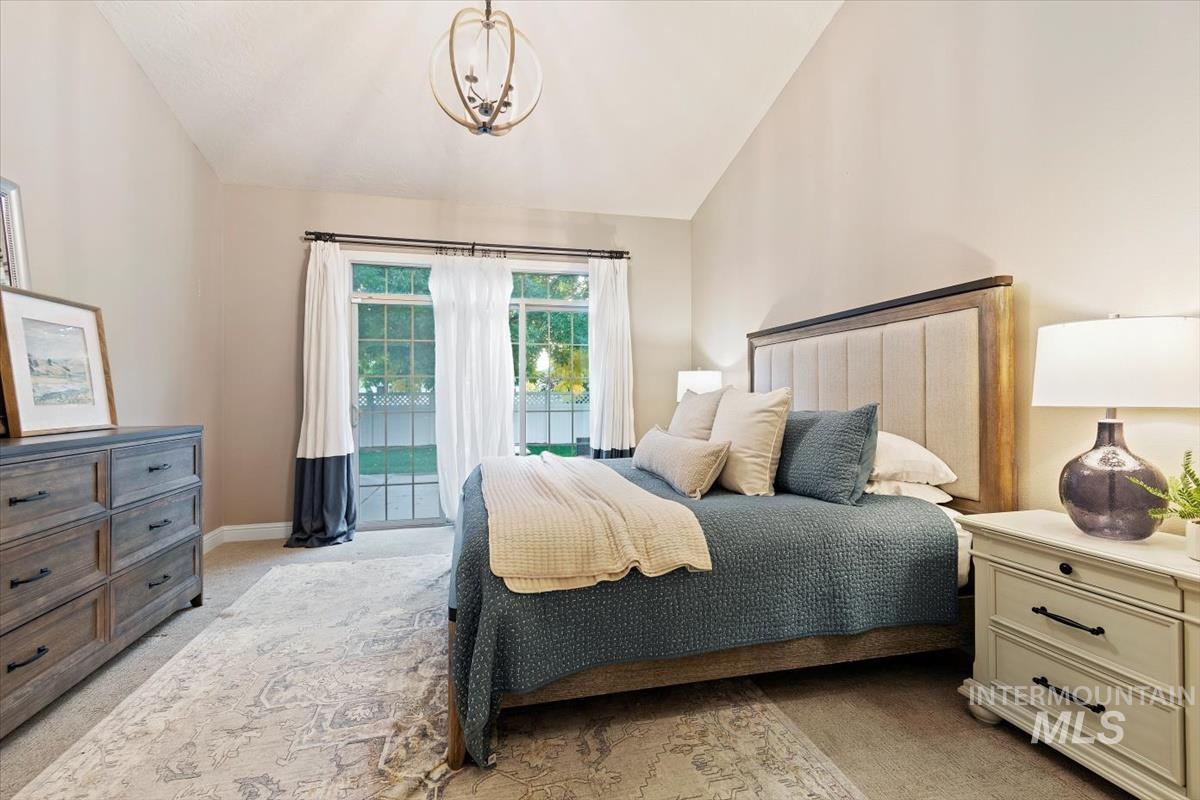 Bedroom with light carpet, access to outside, and lofted ceiling