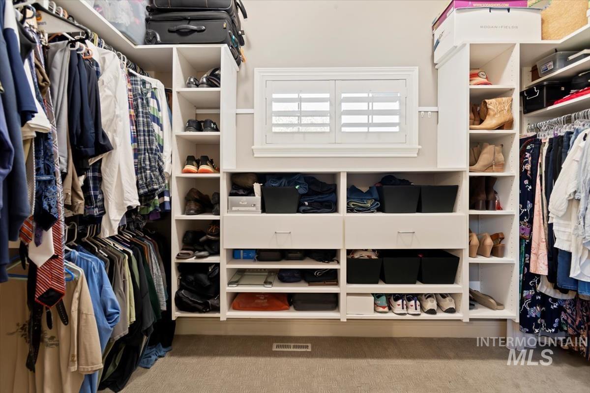 Spacious closet featuring light colored carpet