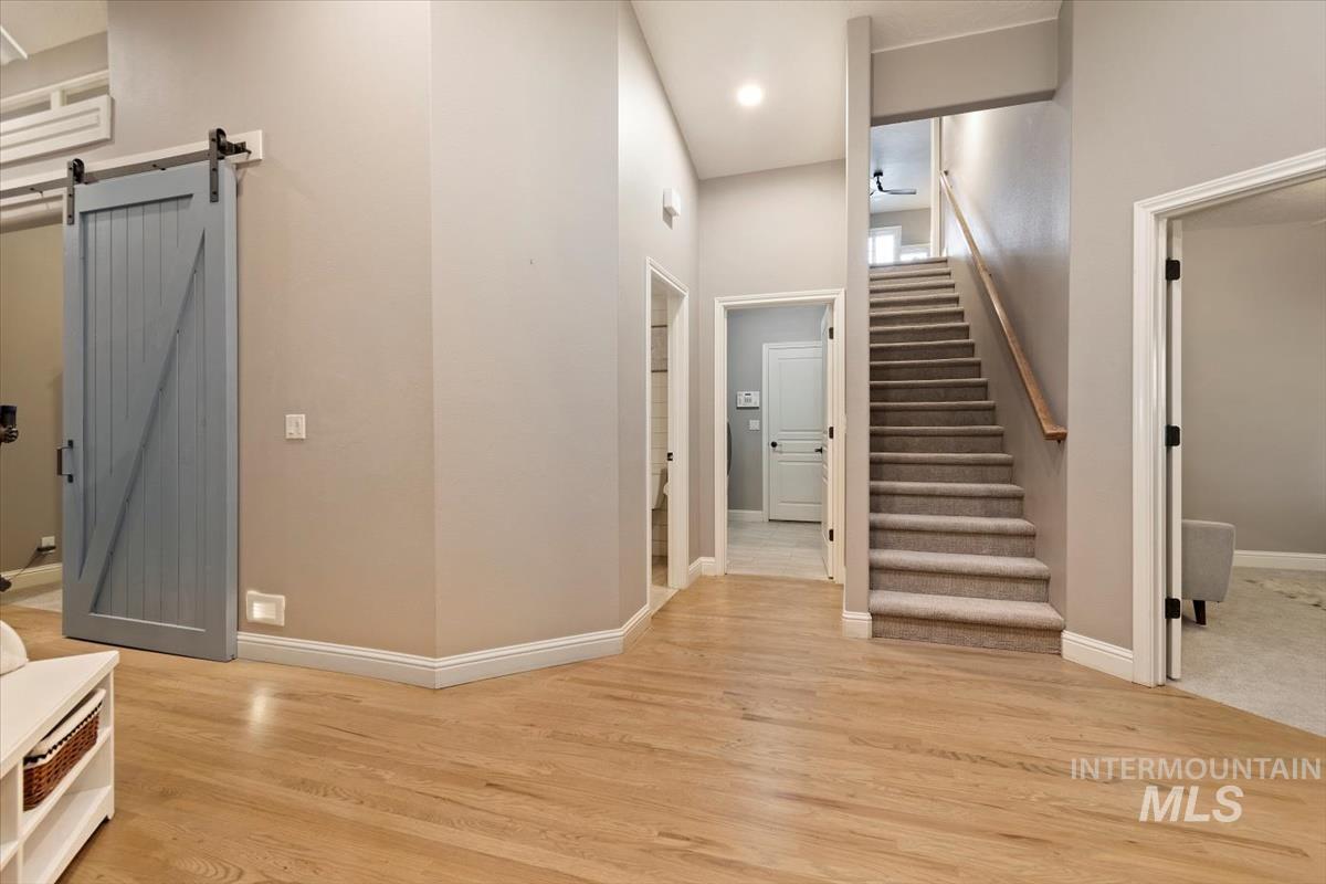 Stairway with a barn door and wood finished floors