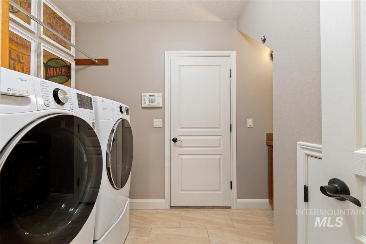 Washroom featuring washing machine and dryer and light tile patterned floors