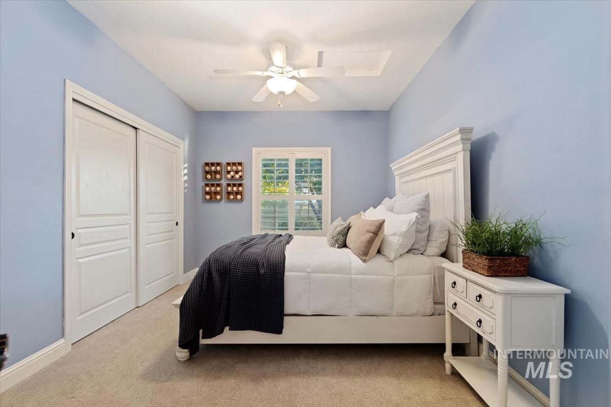 Carpeted bedroom featuring a closet and ceiling fan