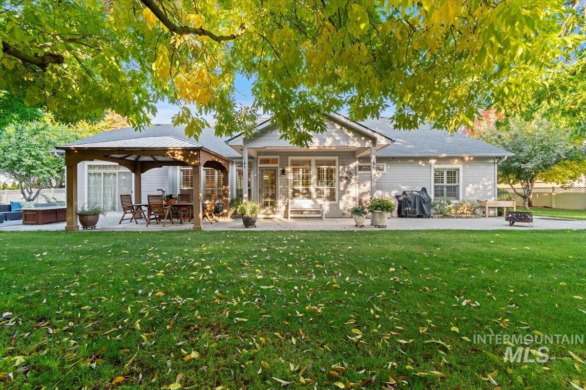 Rear view of property with a patio area, a gazebo, a yard, and a jacuzzi