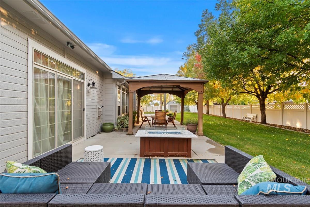 Fenced backyard with a gazebo, a patio, outdoor lounge area, and a shed
