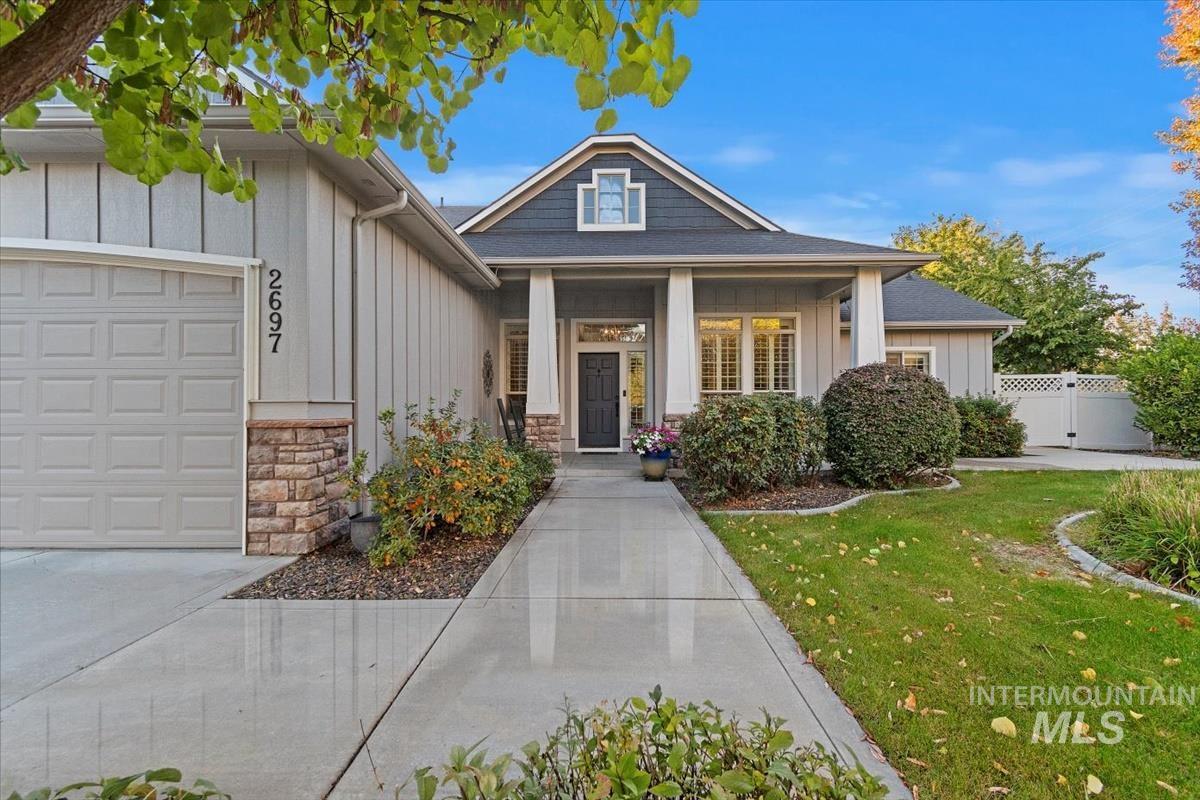 Craftsman-style home featuring board and batten siding, covered porch, stone siding, and a garage