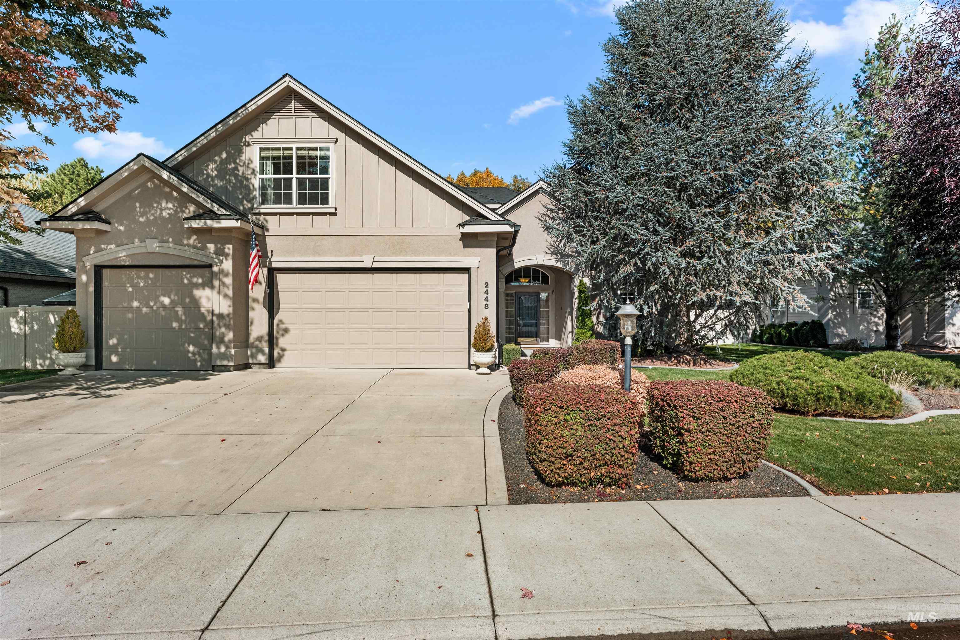 Traditional-style house featuring board and batten siding, driveway, and stucco siding