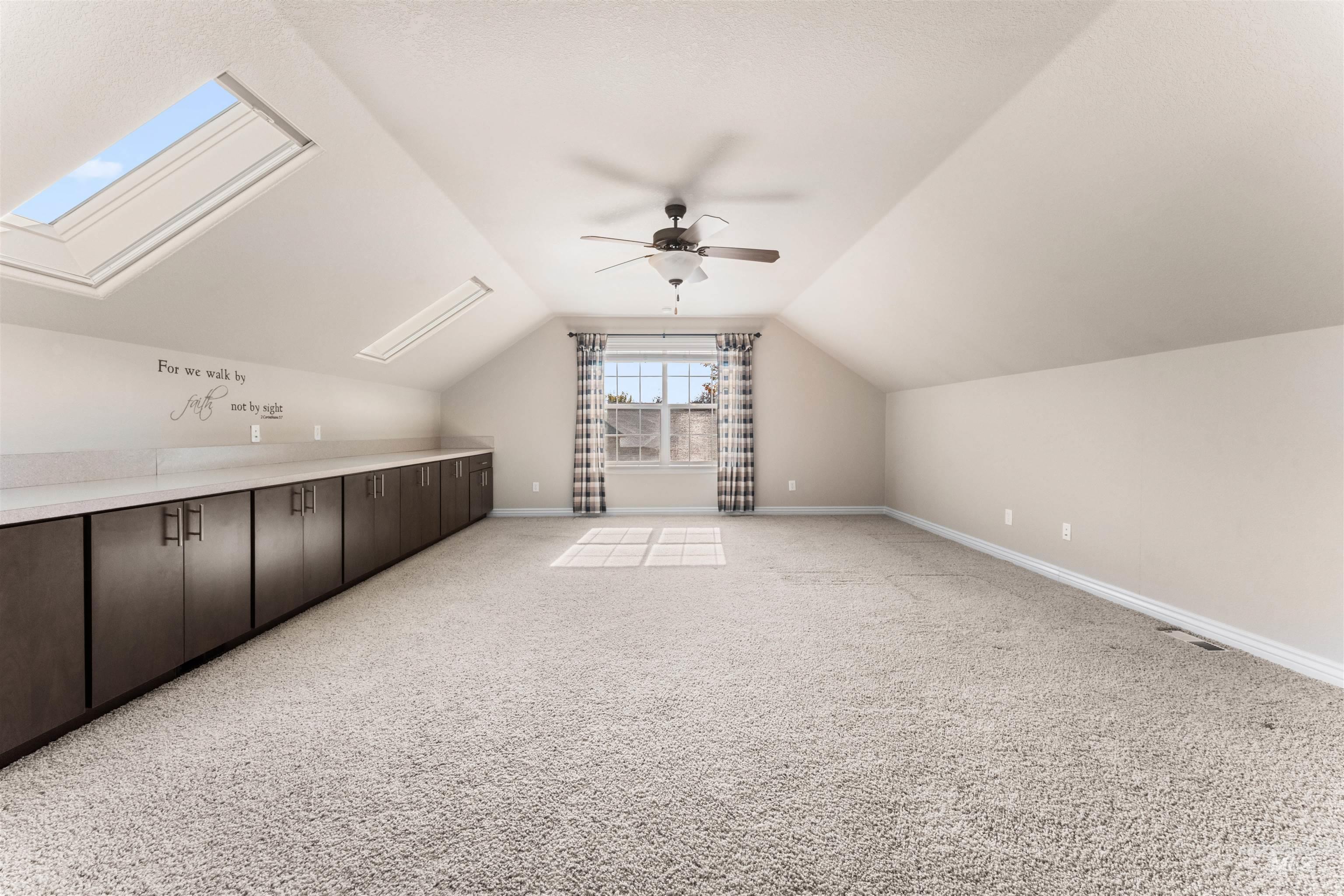 Additional living space with a skylight, lofted ceiling, and light carpet