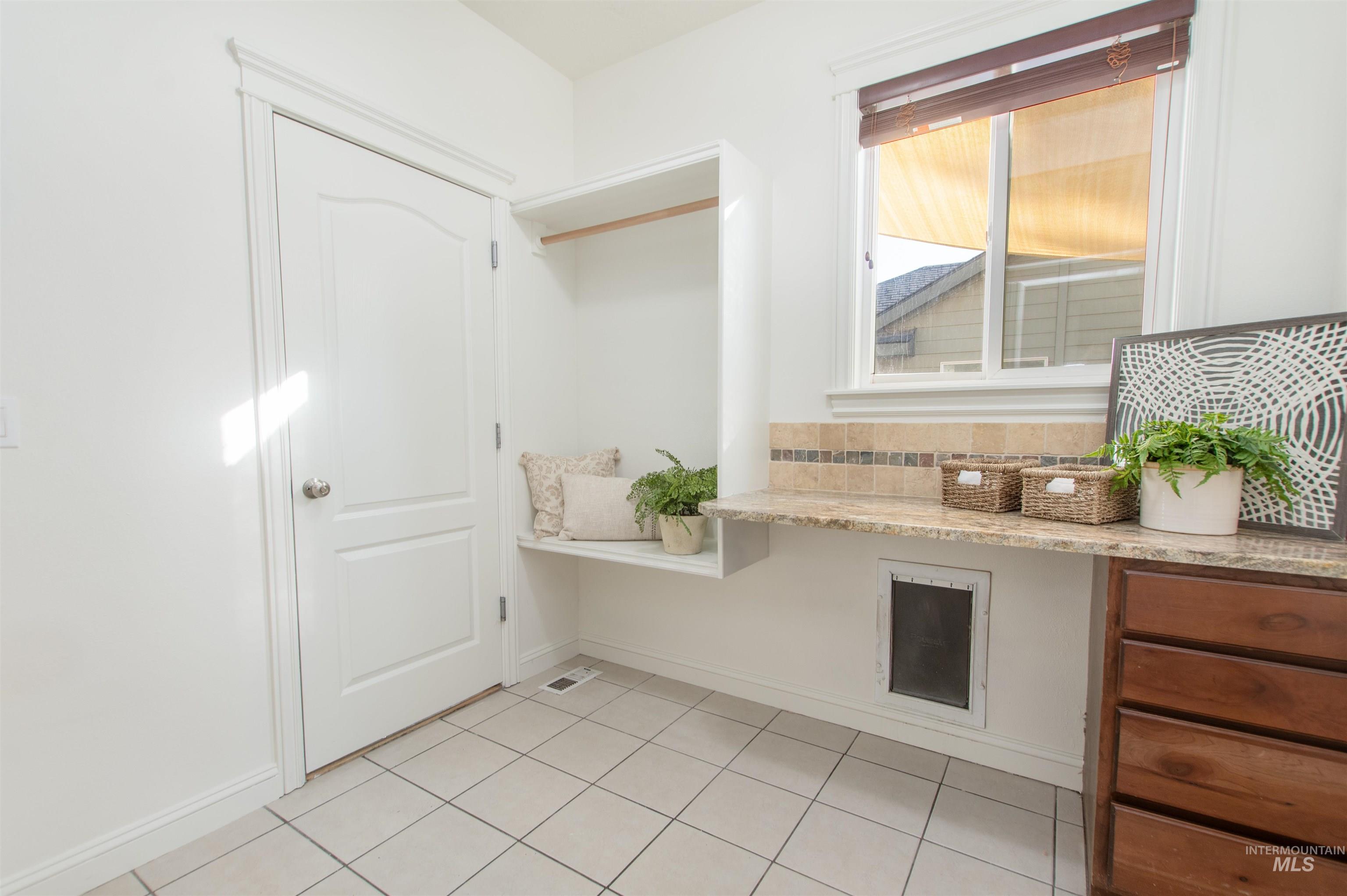 Mudroom featuring light tile patterned flooring and baseboards