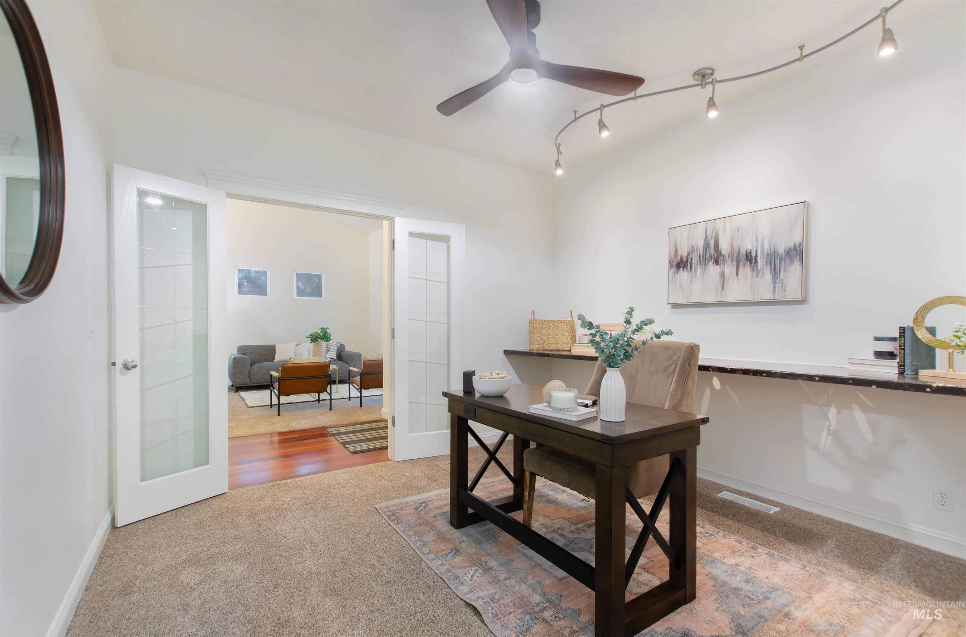 Office featuring light colored carpet, a ceiling fan, and rail lighting