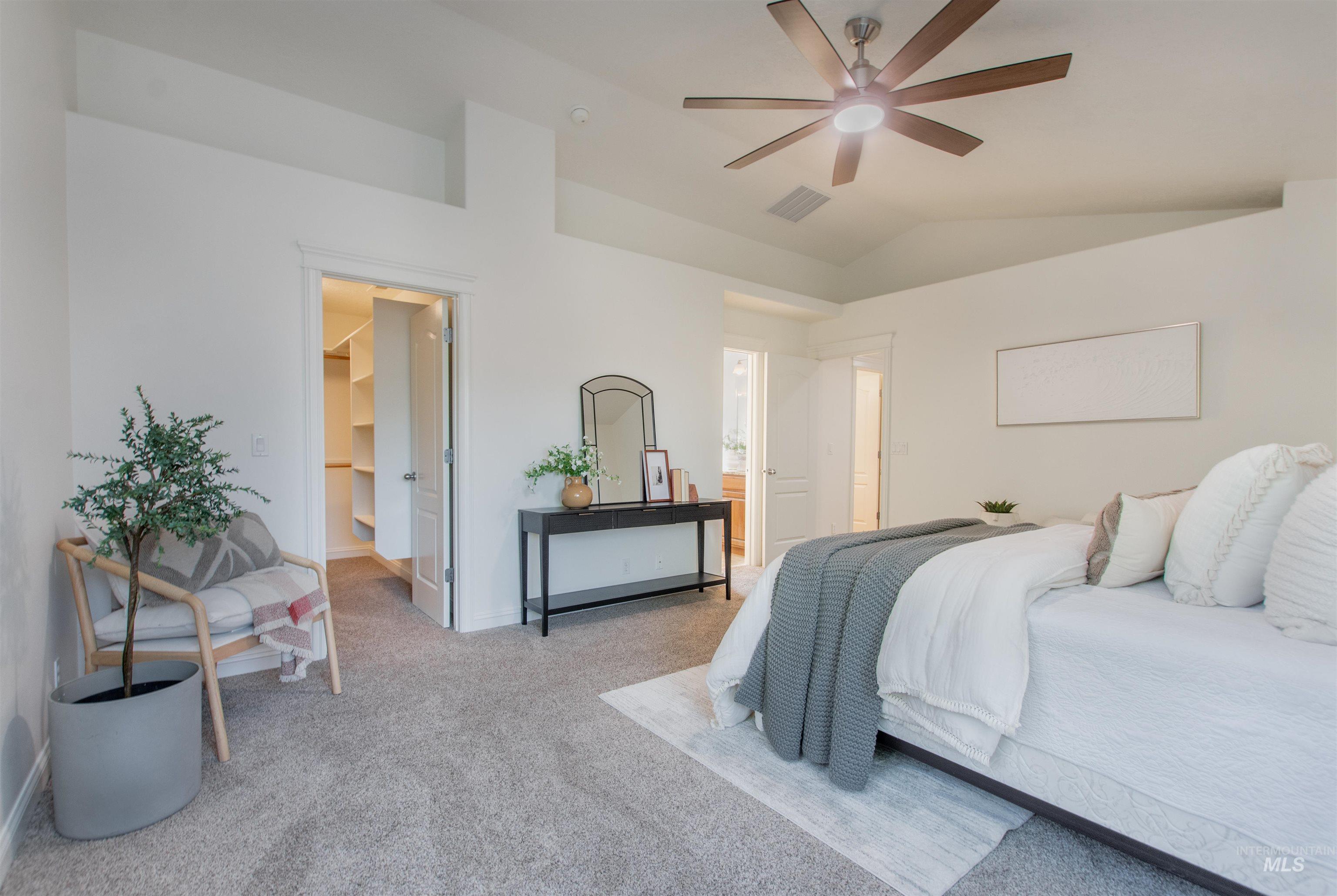 Bedroom featuring carpet flooring, a walk in closet, ceiling fan, and lofted ceiling