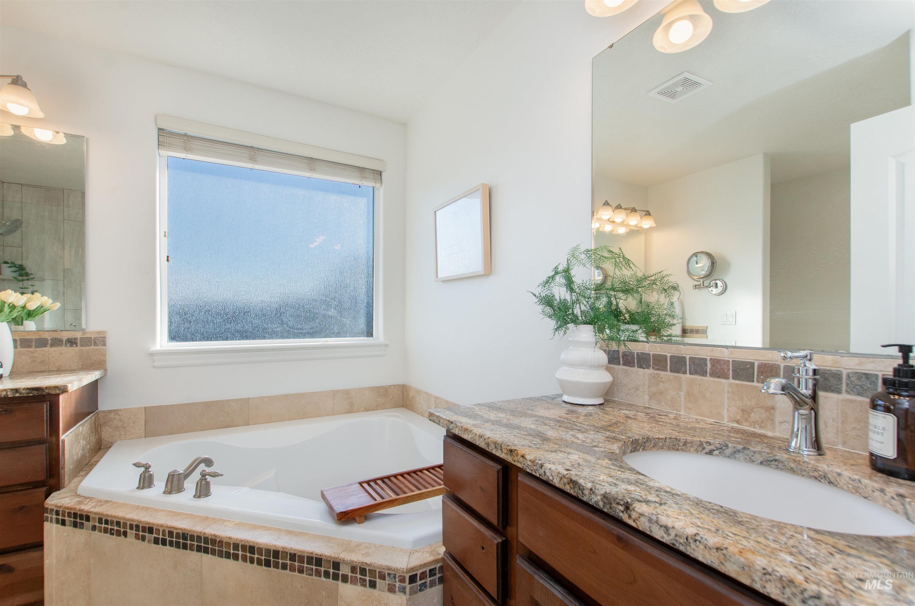 Bathroom featuring vanity and a garden tub