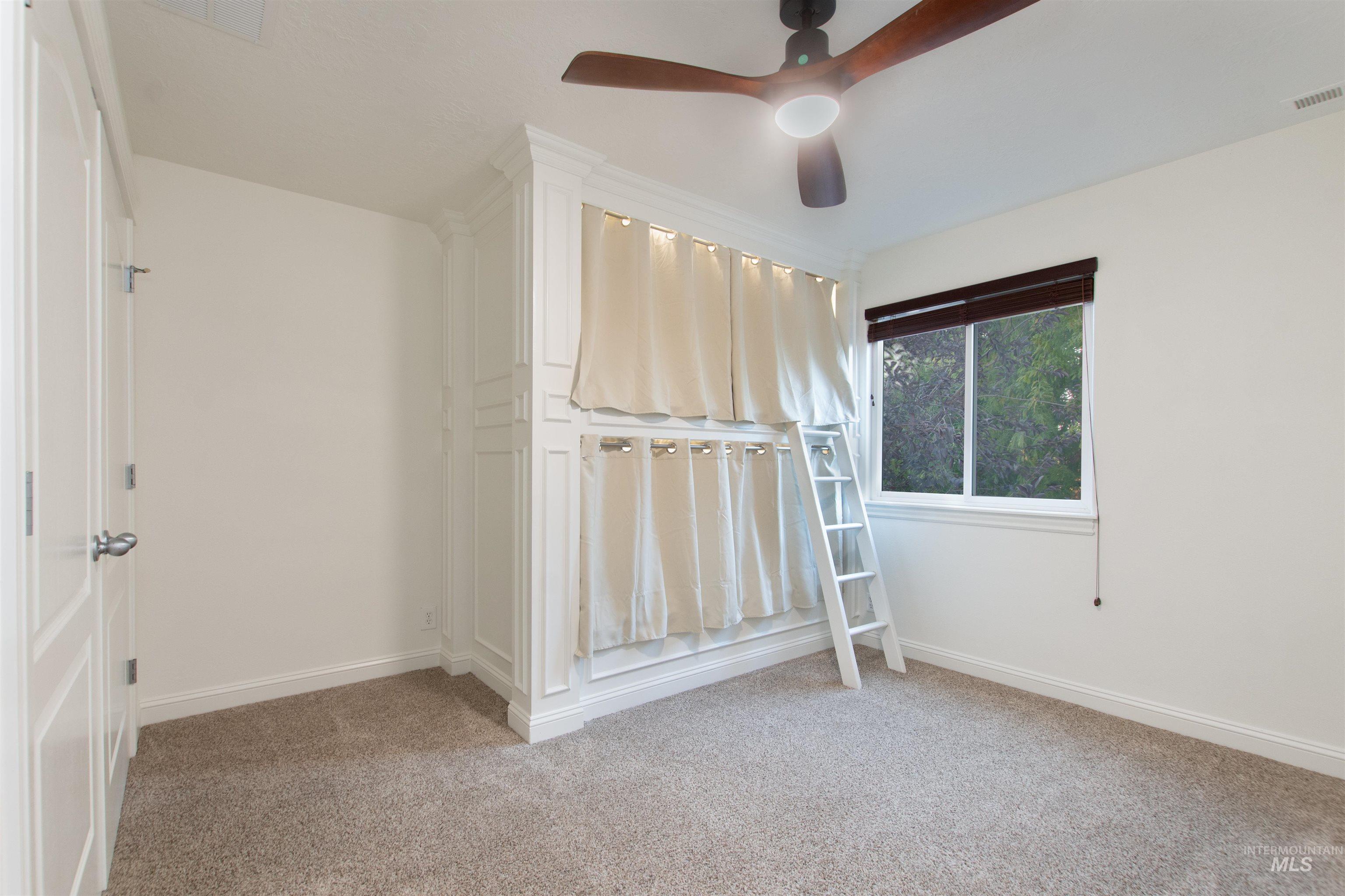 Unfurnished bedroom featuring light carpet and a ceiling fan