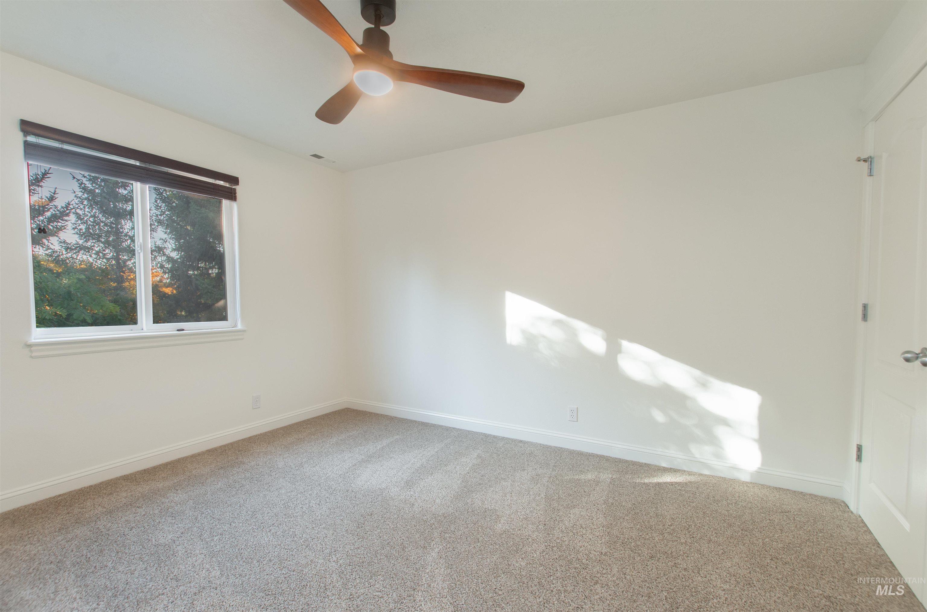 Unfurnished room featuring light carpet and ceiling fan