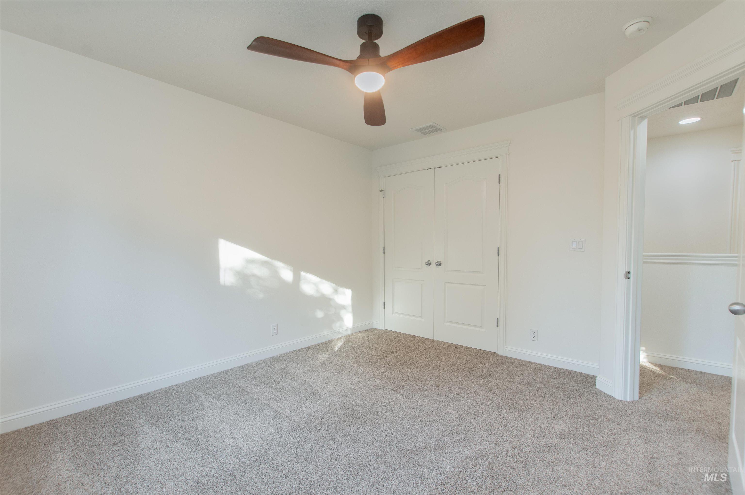 Unfurnished bedroom with carpet flooring, a closet, and a ceiling fan