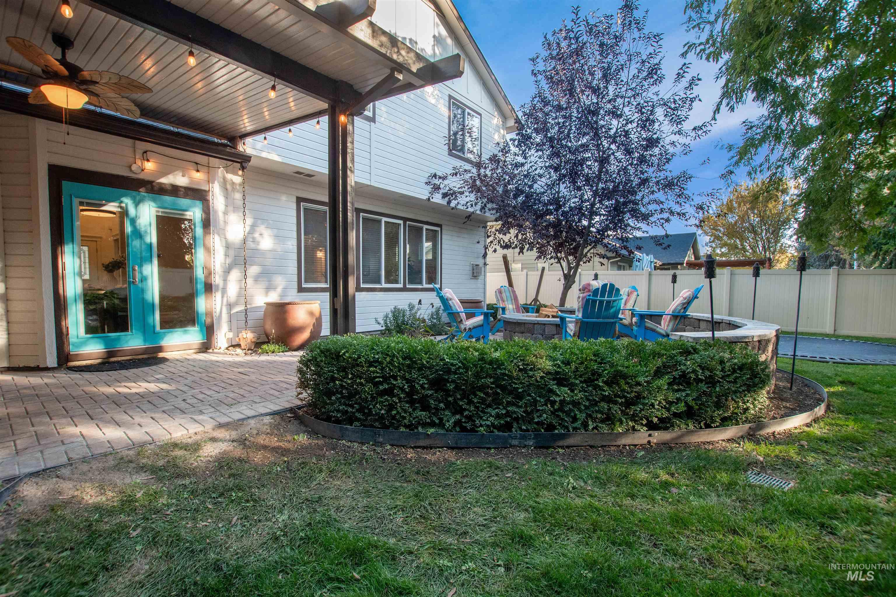 View of yard featuring a patio, ceiling fan, an outdoor fire pit, and french doors