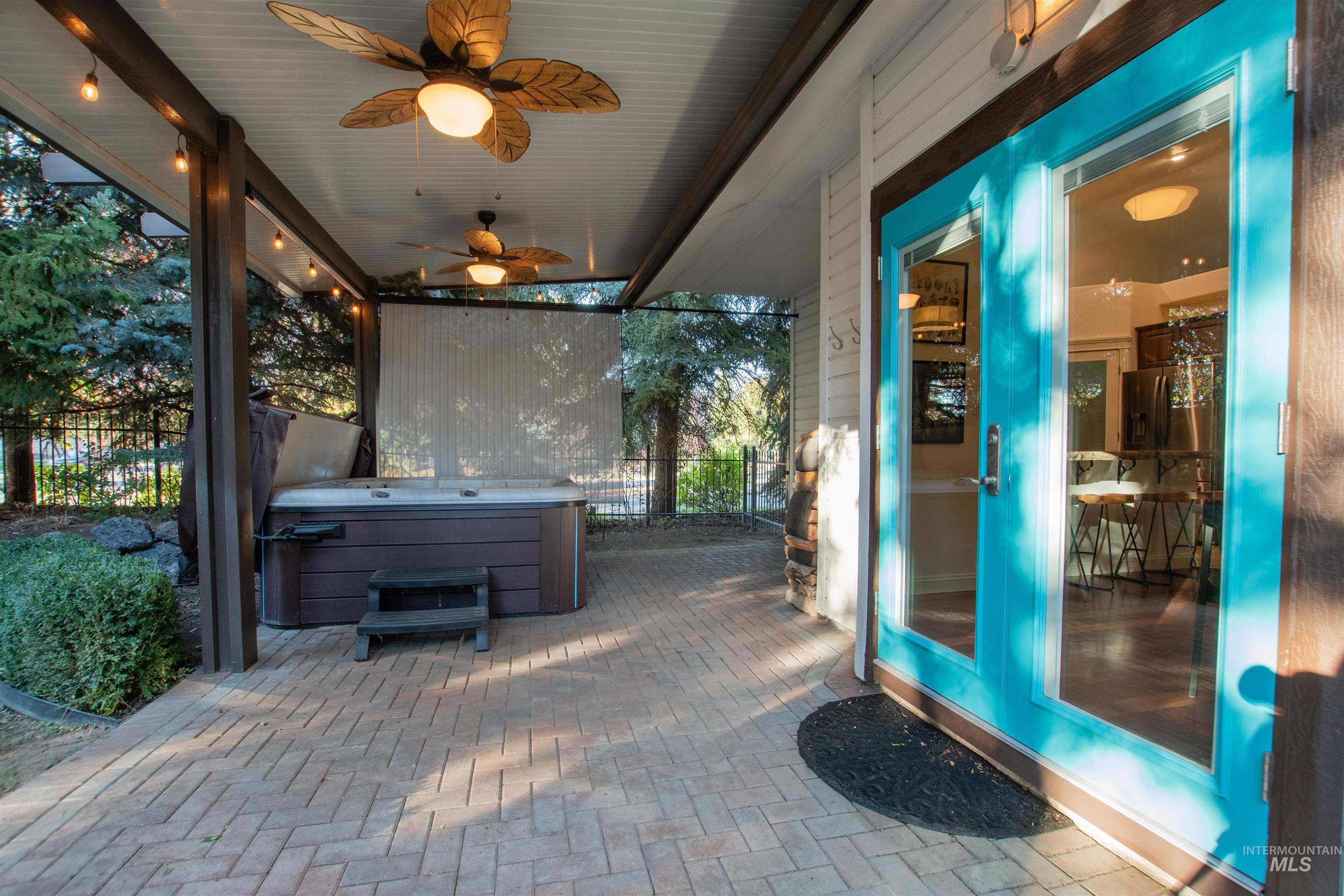 View of patio / terrace with a ceiling fan and a hot tub