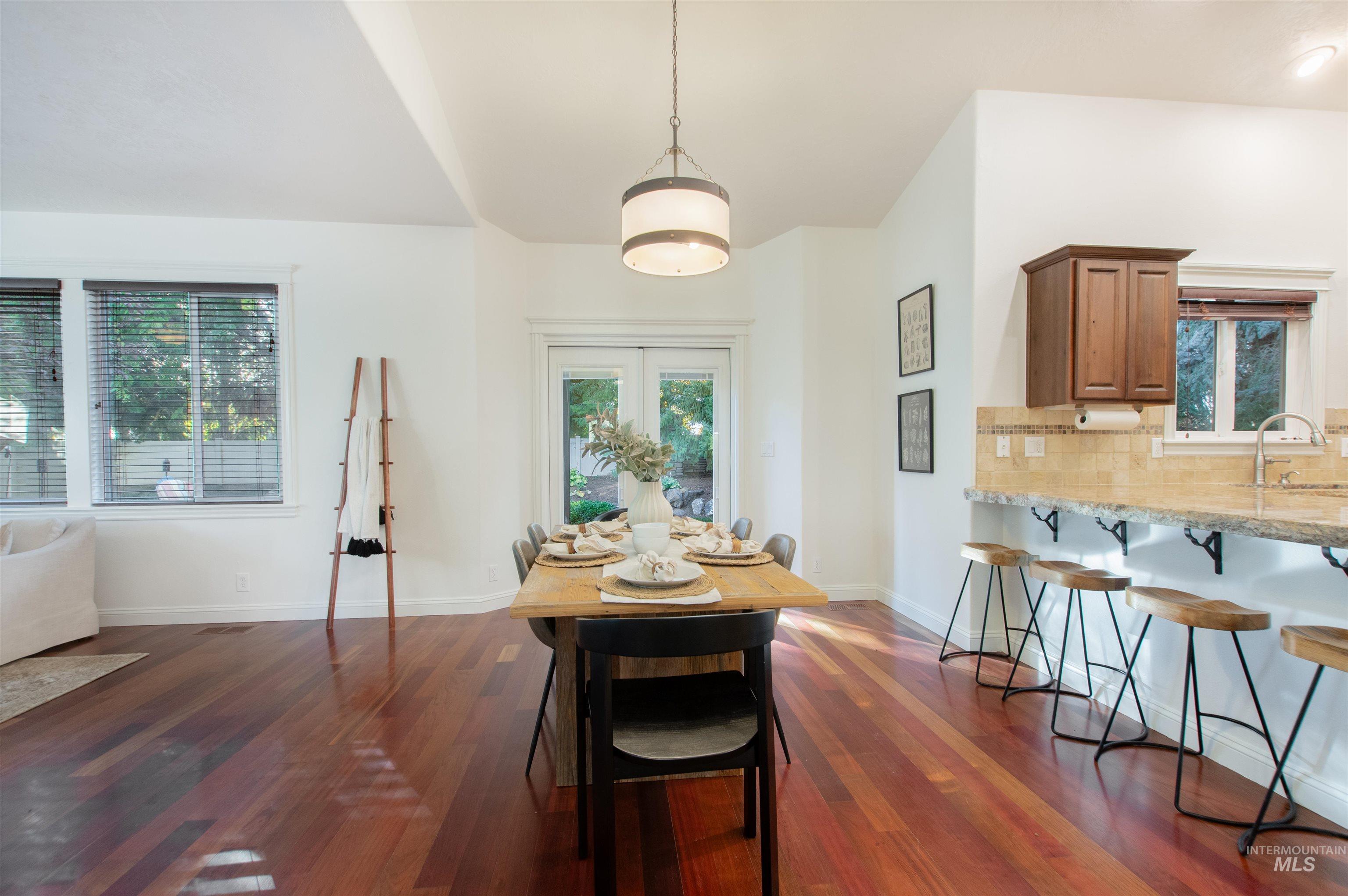 Dining area with healthy amount of natural light and dark wood finished floors