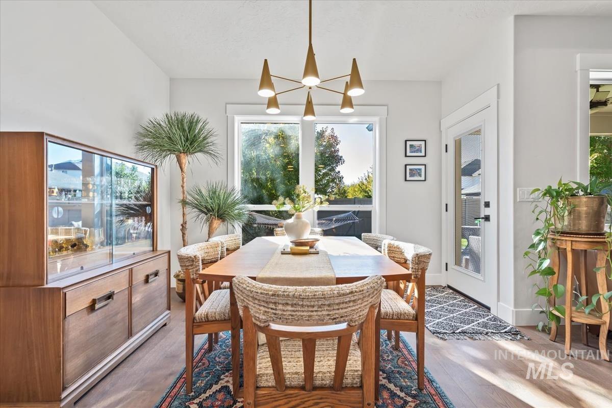 Dining space with plenty of natural light, dark wood-style flooring, and a chandelier