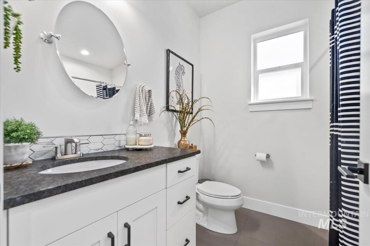 Bathroom featuring dark tile patterned floors, vanity, and a shower with curtain