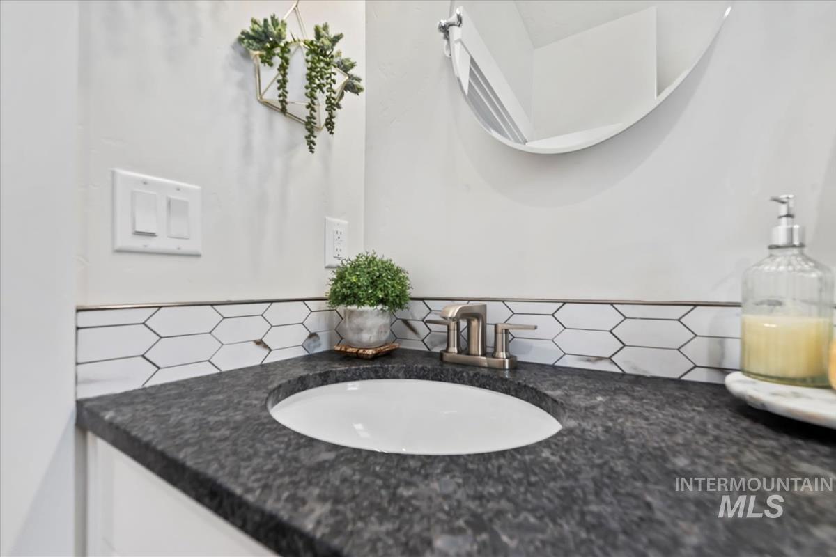 Bathroom with vanity and decorative backsplash