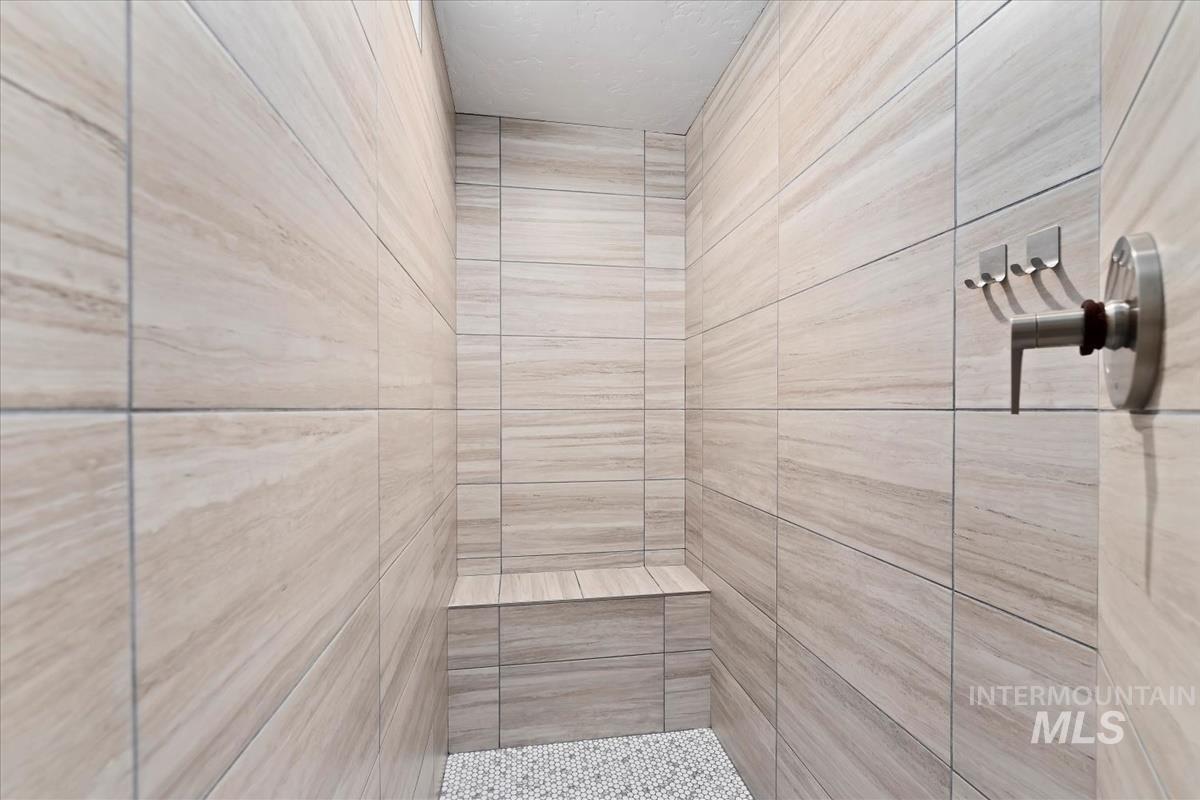 Bathroom view of tiled shower and a relaxing sauna