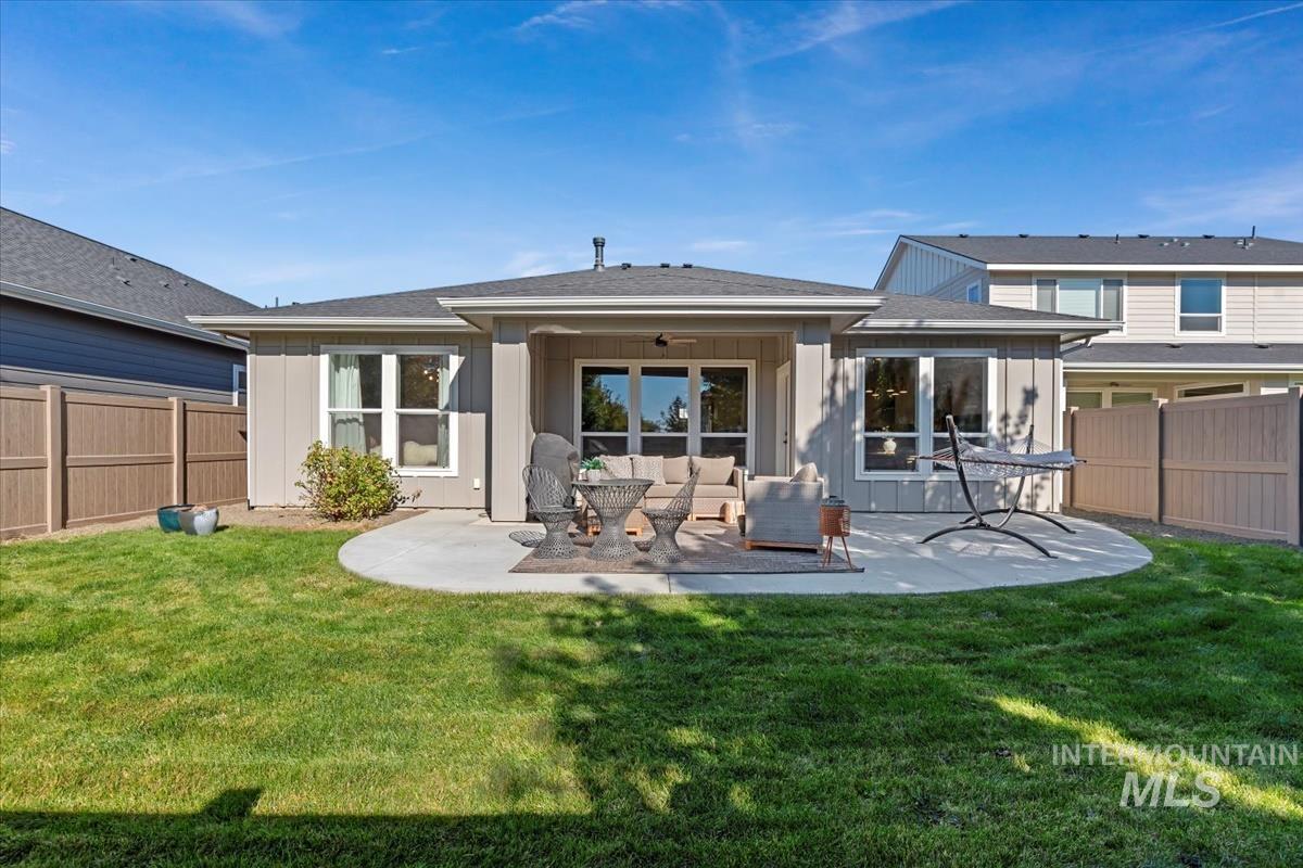 Back of property featuring a fenced backyard, a patio, an outdoor living space, and a shingled roof