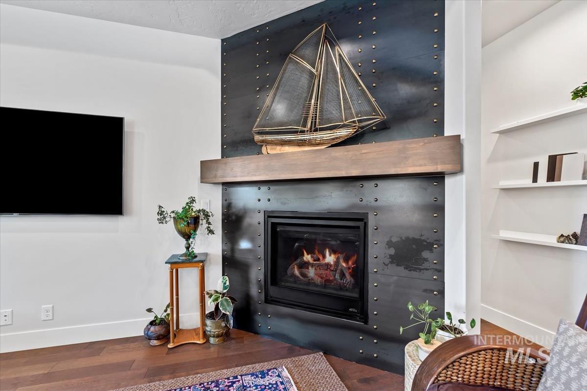 Detailed view of wood finished floors and a glass covered fireplace