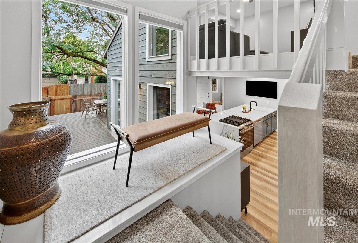 Living room featuring stairway, light wood-type flooring, and a fireplace
