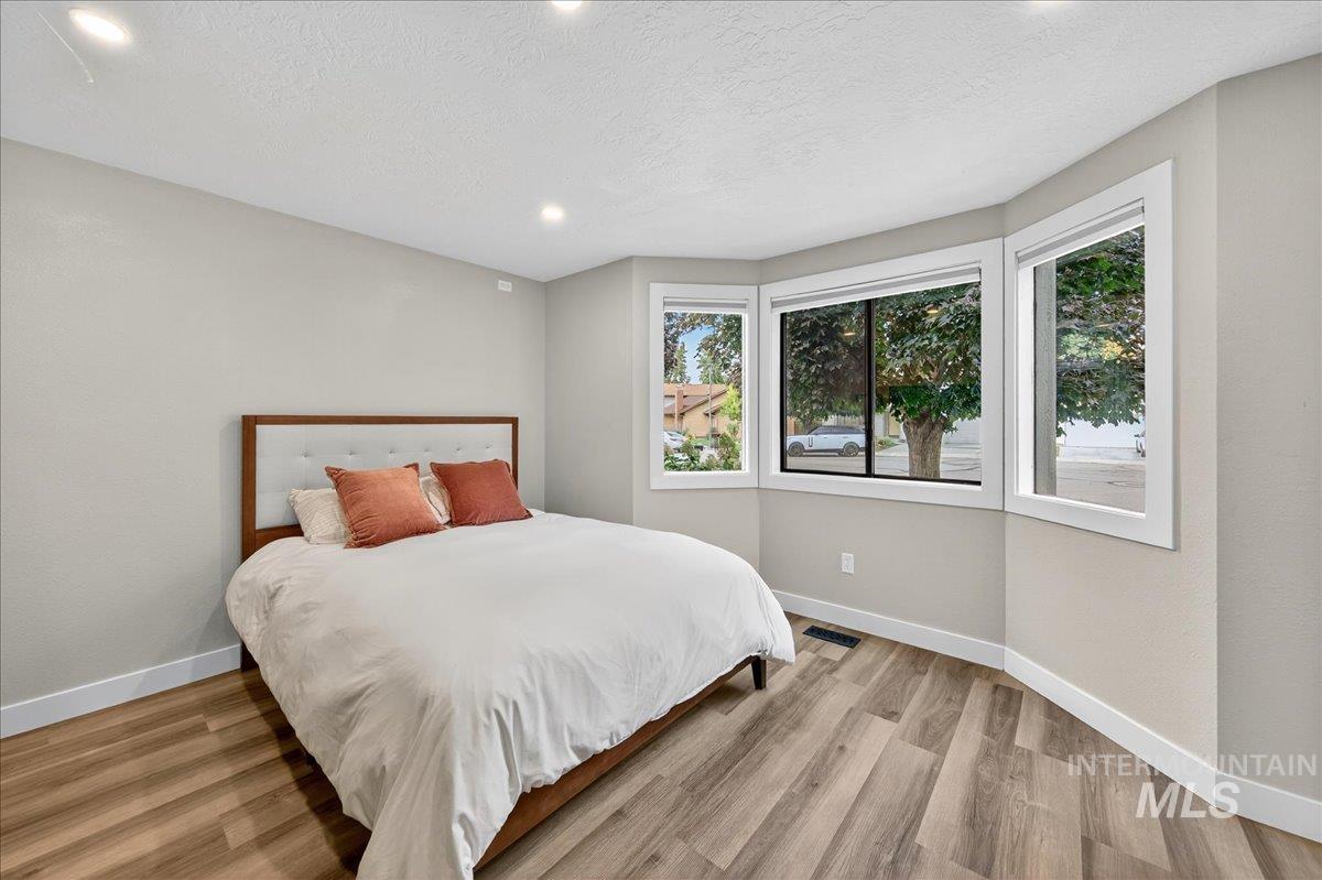 Bedroom with light wood-style flooring, recessed lighting, and a textured ceiling