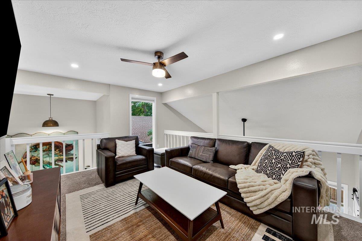 Living area featuring ceiling fan, recessed lighting, carpet, and a textured ceiling