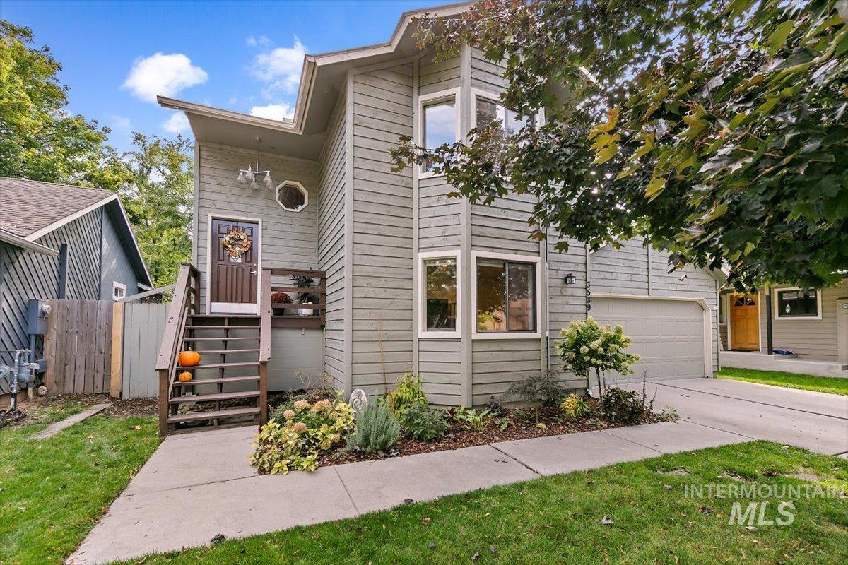 View of front of property featuring a garage, stairs, and concrete driveway