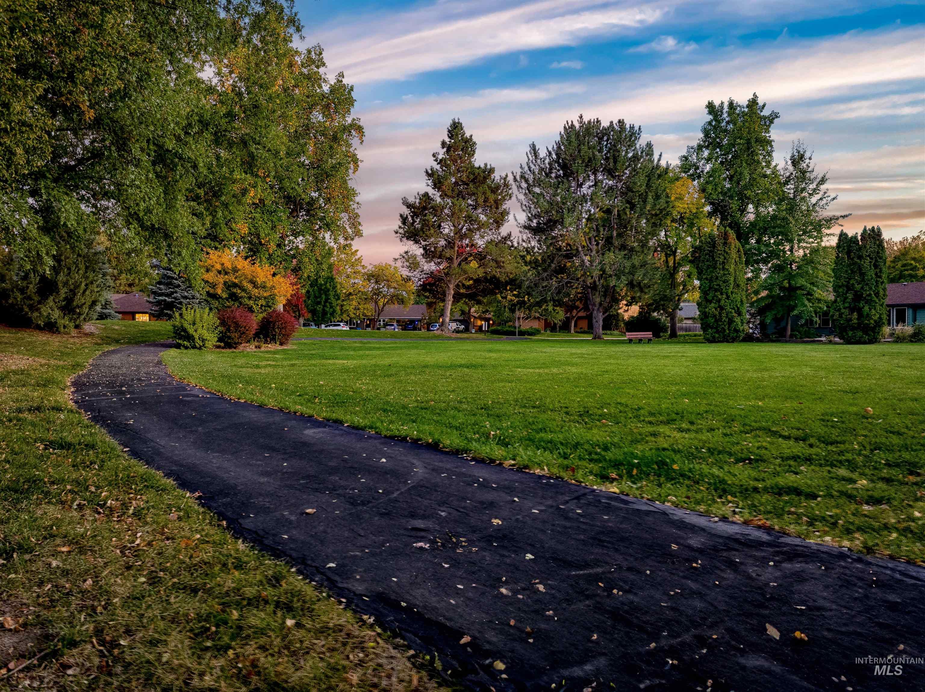 Surrounding community with a lawn and view of wooded area