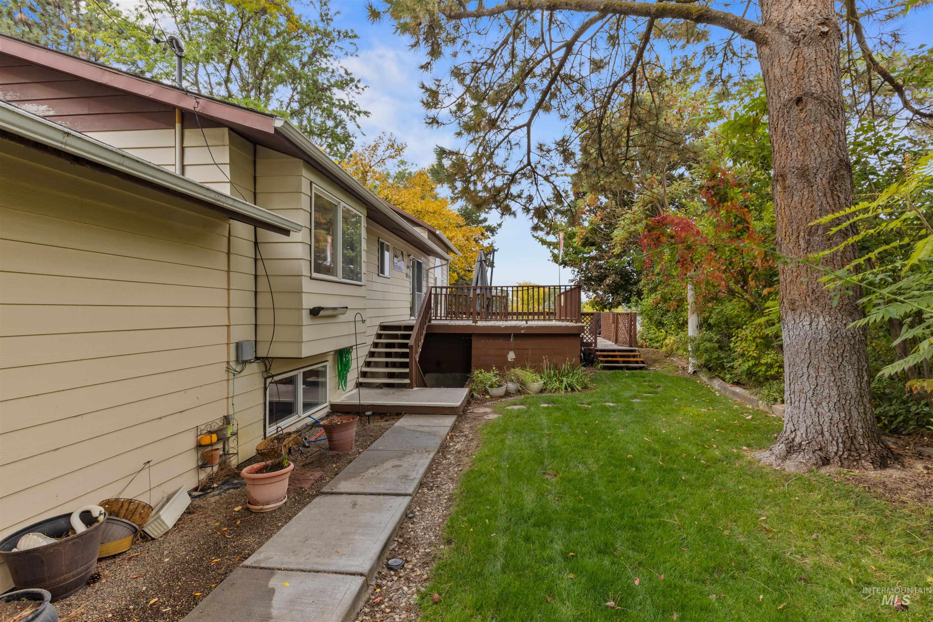 View of grassy yard with stairway and a deck