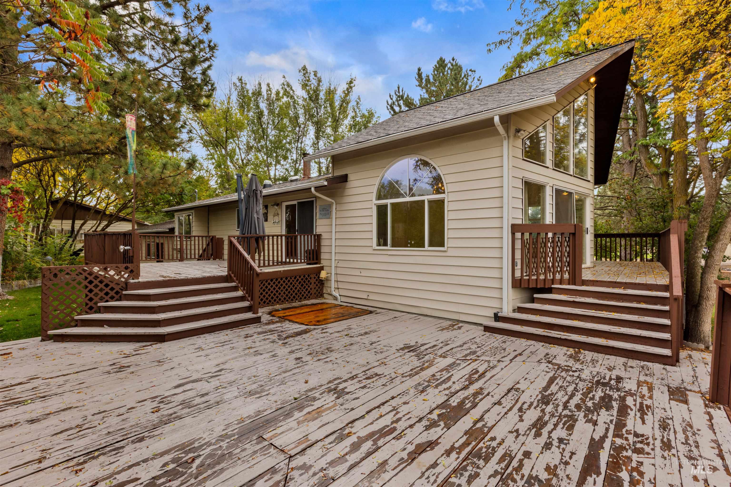 Rear view of house featuring a wooden deck and roof with shingles