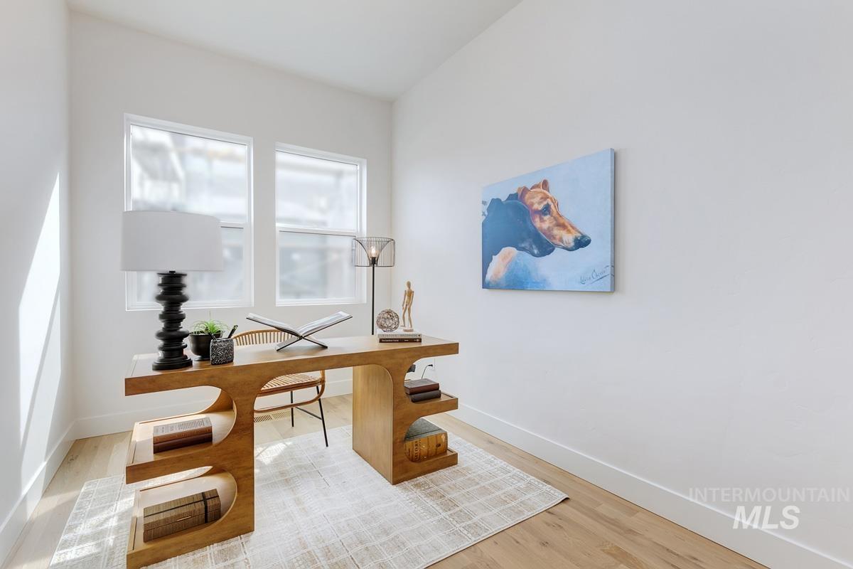 Home office with light wood finished floors and baseboards