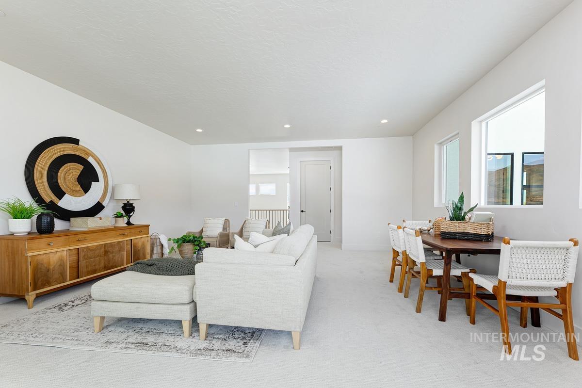 Living area featuring light colored carpet and recessed lighting